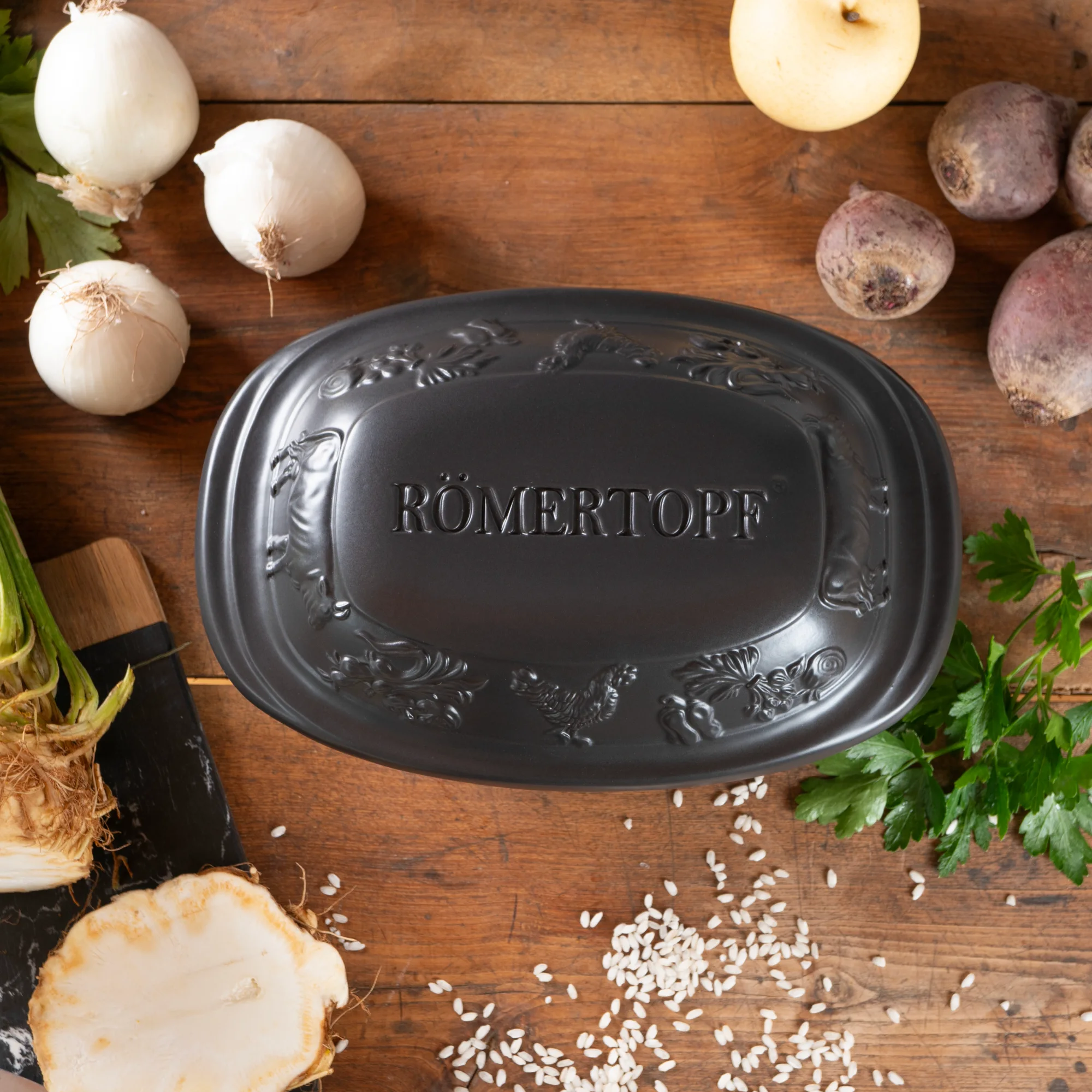 RÖMERTOPF Mini Bräter schwarz – Keramik Kochtopf mit Deckel für schonende Zubereitung im Ofen Schwarzer Römertopf Mini-Bräter mit Deckel aus Keramik, rechteckige Form, auf heller Oberfläche stehend.