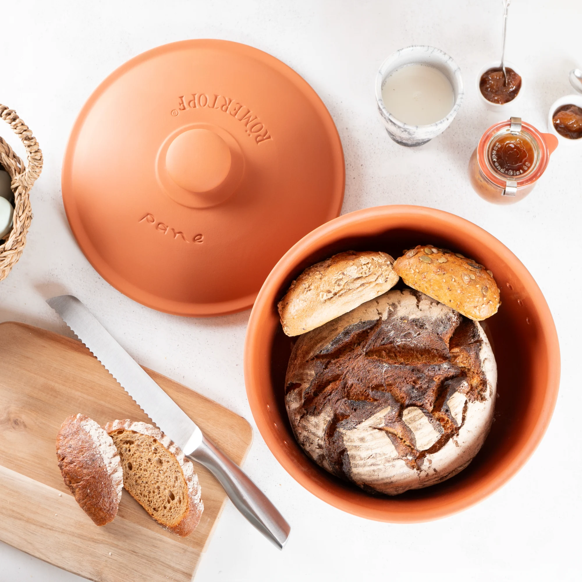 Römertopf Brottopf rund aus Terrakotta – Atmungsaktiver Frischetopf zur Brotaufbewahrung Runder Brottopf aus Terrakotta mit passendem Deckel, naturfarben mit belüftender Lochstruktur, auf weißem Hintergrund.