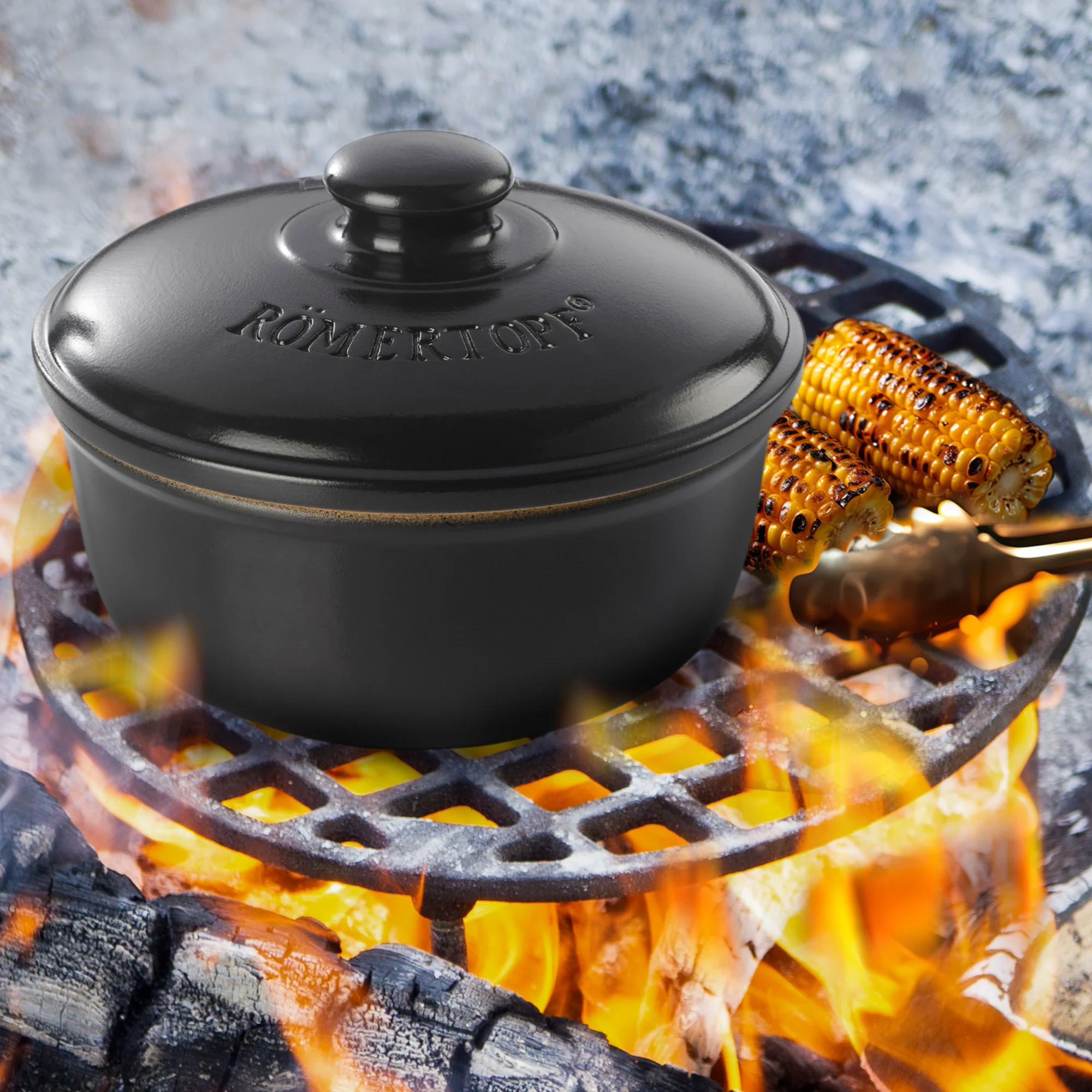Römertopf BBQ Schmortopf aus Keramik mit Deckel – Ideal für Grill und Backofen Schwarzer Römertopf BBQ-Schmortopf mit Deckel, seitlich zwei Griffe, deckellos präsentiert, daneben angerichtetes Grillgemüse; platziert auf heller Oberfläche mit dunklem Hintergrund.