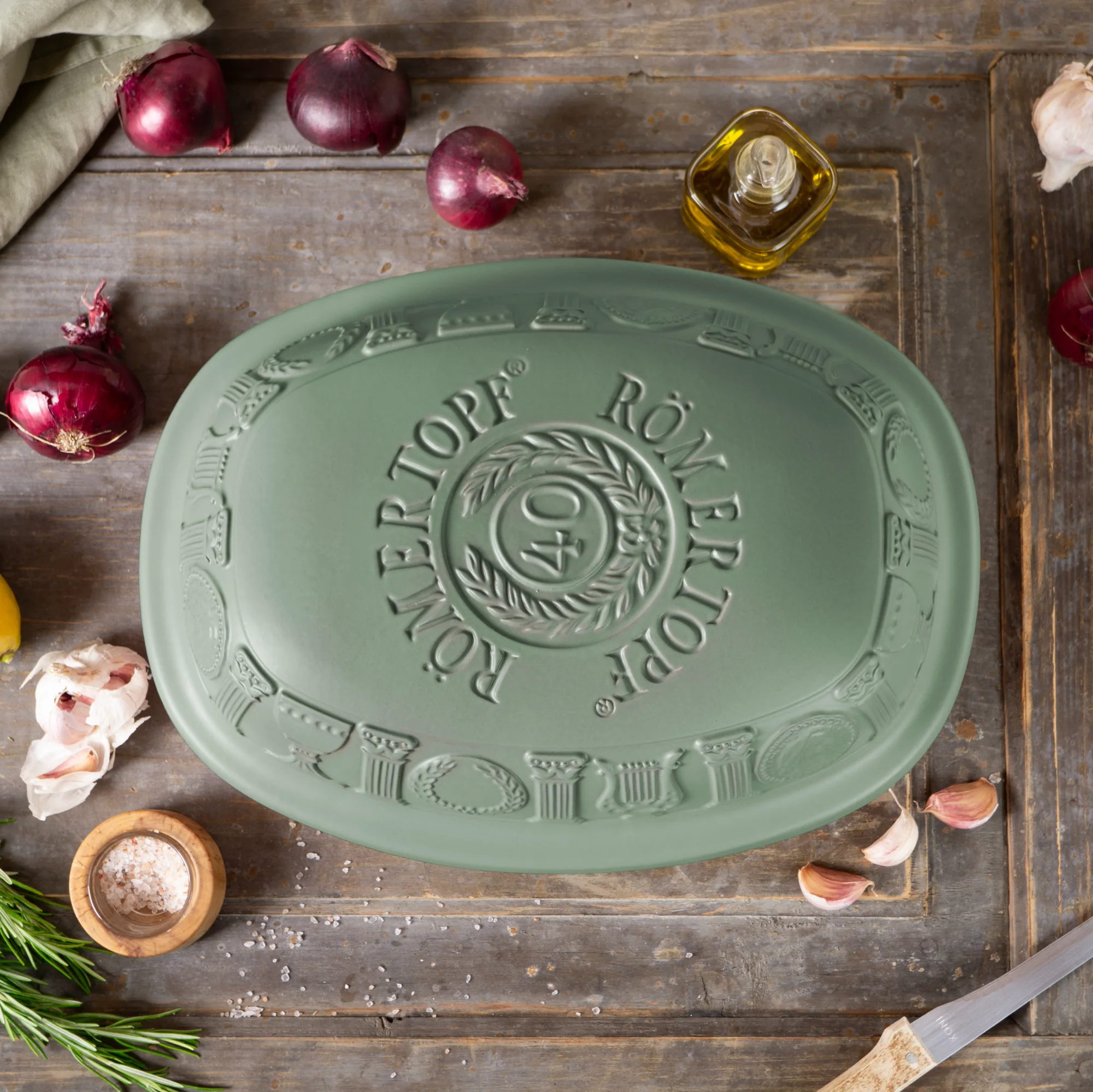 RÖMERTOPF Bräter 40 Jahre Jubiläumsedition grün – Keramik-Backform mit Deckel Grüner Römertopf-Bräter in limitierter 40-Jahre-Edition mit passendem Deckel, auf einem hellen Hintergrund platziert.