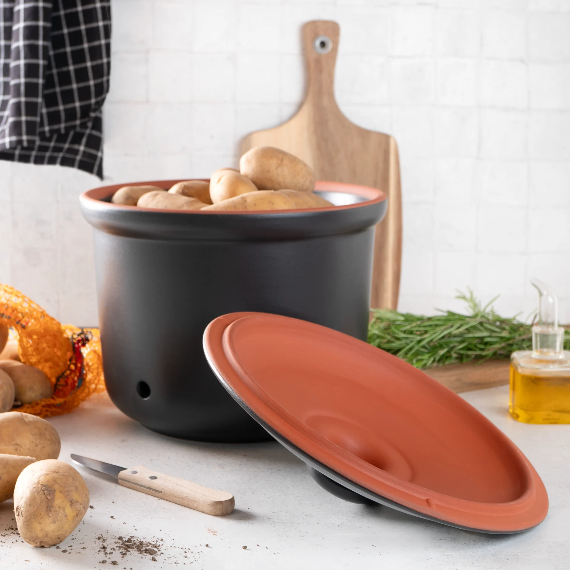 Römertopf Kartoffeltopf aus Keramik in Schwarz – atmungsaktiver Vorratstopf zur Lagerung von Kartoffeln Schwarzer Römertopf-Kartoffeltopf mit Deckel, aus Keramik, stehend auf hellem Untergrund – das klassische Runddesign zeigt seitliche Griffe und eine matte Oberfläche.