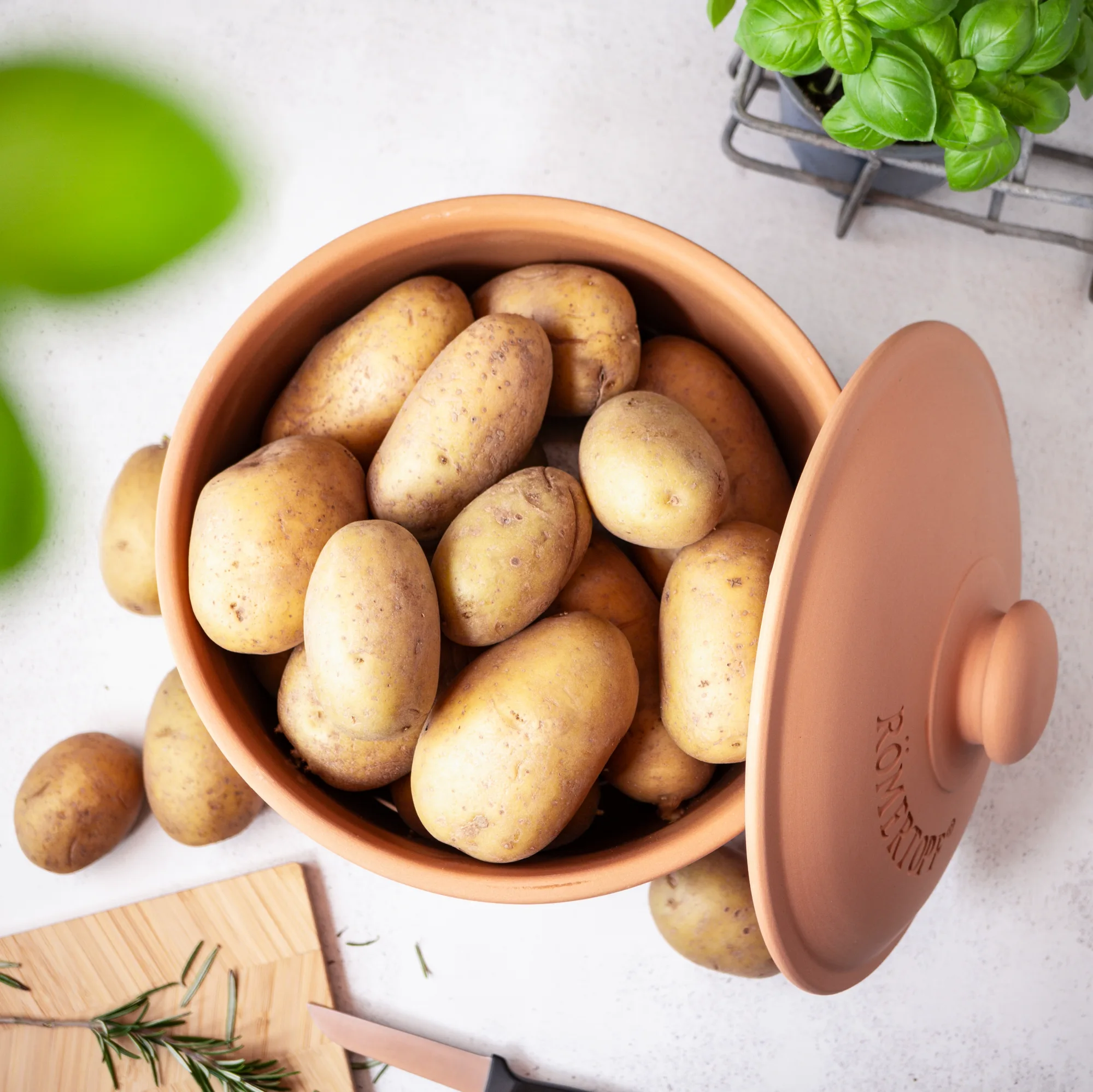 Römertopf Kartoffeltopf Maxi Plus – Großer Keramiktopf zur Aufbewahrung von Kartoffeln ohne Kunststoff Großer Römertopf-Keramiktopf in Beige mit Deckel und seitlichen Griffen, speziell für die Aufbewahrung von Kartoffeln, auf weißem Hintergrund.