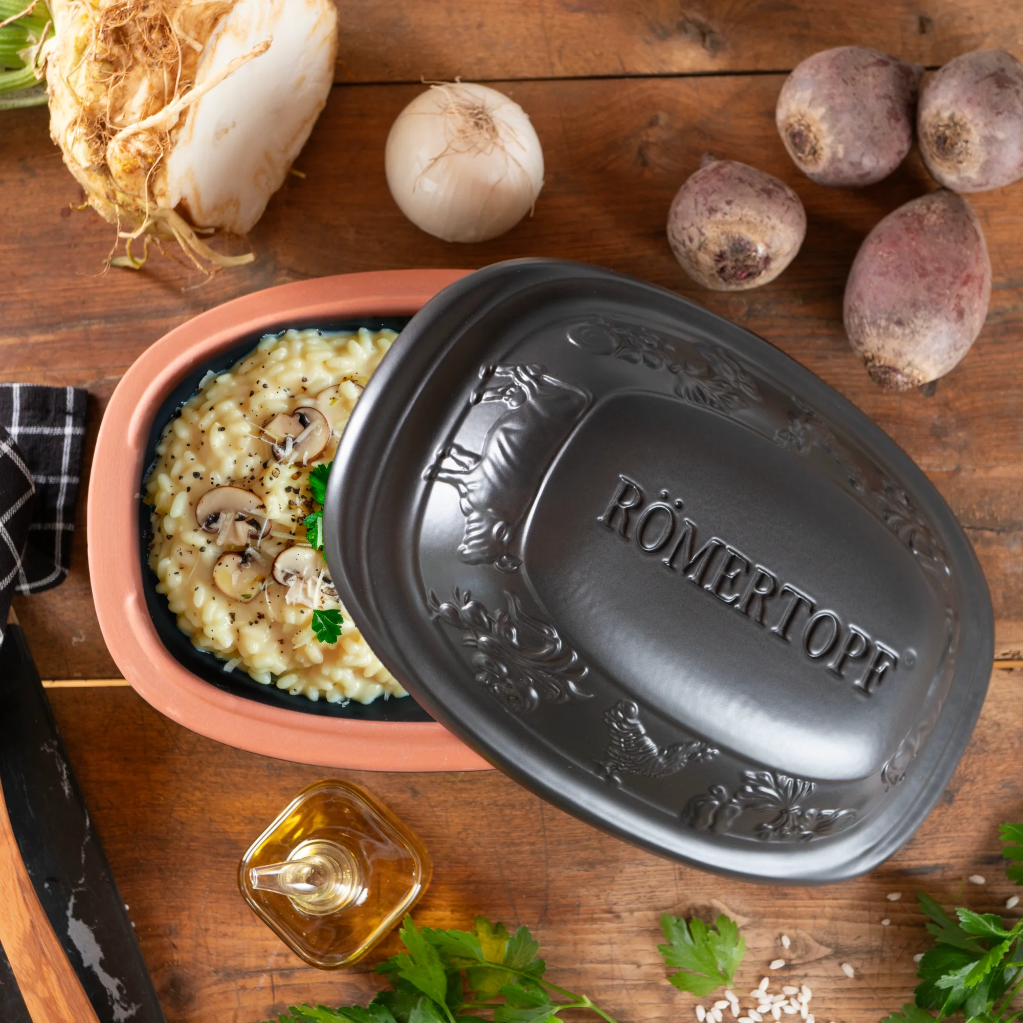 Römertopf Mini Bräter schwarz – kleiner Tontopf zum fettarmen Garen im Ofen Schwarzer Römertopf Mini-Bräter aus Keramik mit Deckel, seitlich auf hellem Untergrund fotografiert, geeignet für kleine Portionen oder Einzelgerichte.