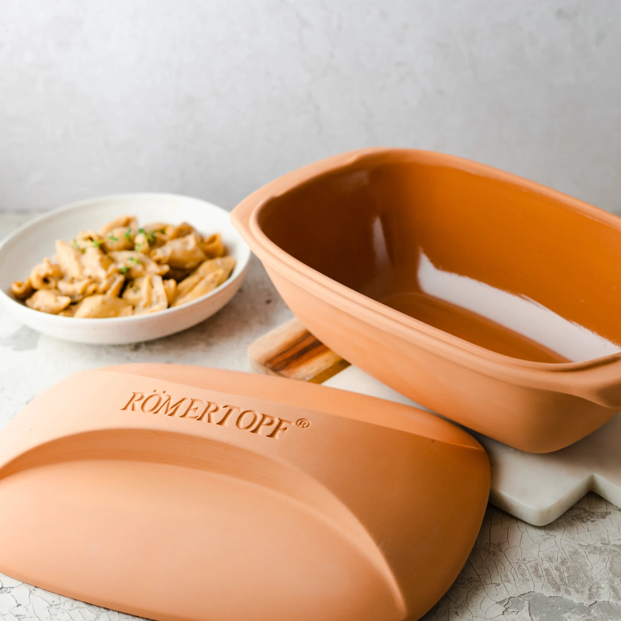 Römertopf Bräter Culinario aus Terrakotta – klassischer Schmortopf für gesundes Kochen Rechteckiger Römertopf-Bräter aus Terrakotta mit Deckel, naturfarben, auf weißem Hintergrund – geeignet zum fettfreien Garen im Ofen.