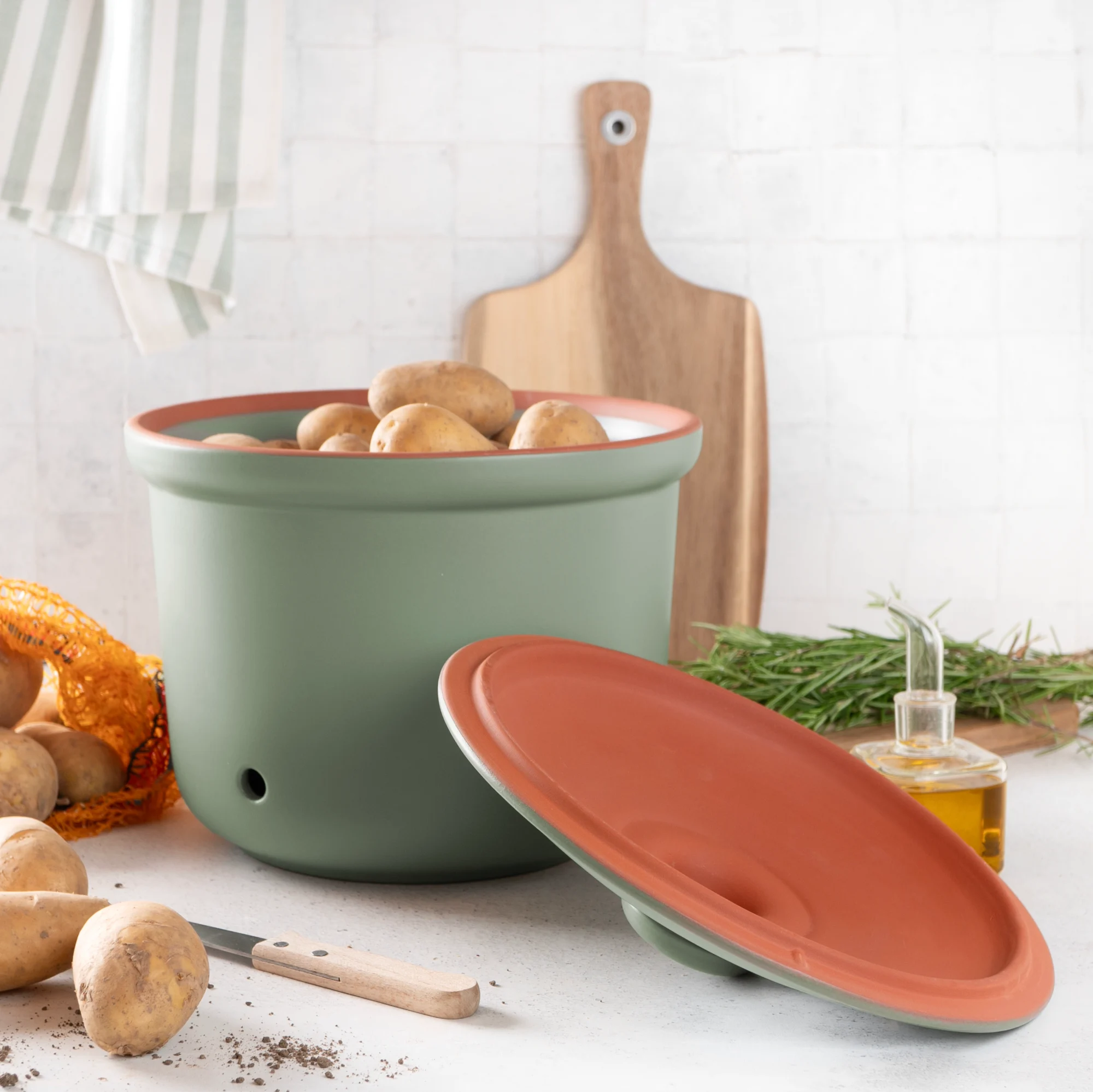 Römertopf Kartoffeltopf grün – atmungsaktiver Tontopf zur optimalen Vorratshaltung von Kartoffeln Grüner Römertopf-Kartoffeltopf aus Keramik mit Deckel und seitlichen Griffen, auf einem hellen Untergrund stehend.