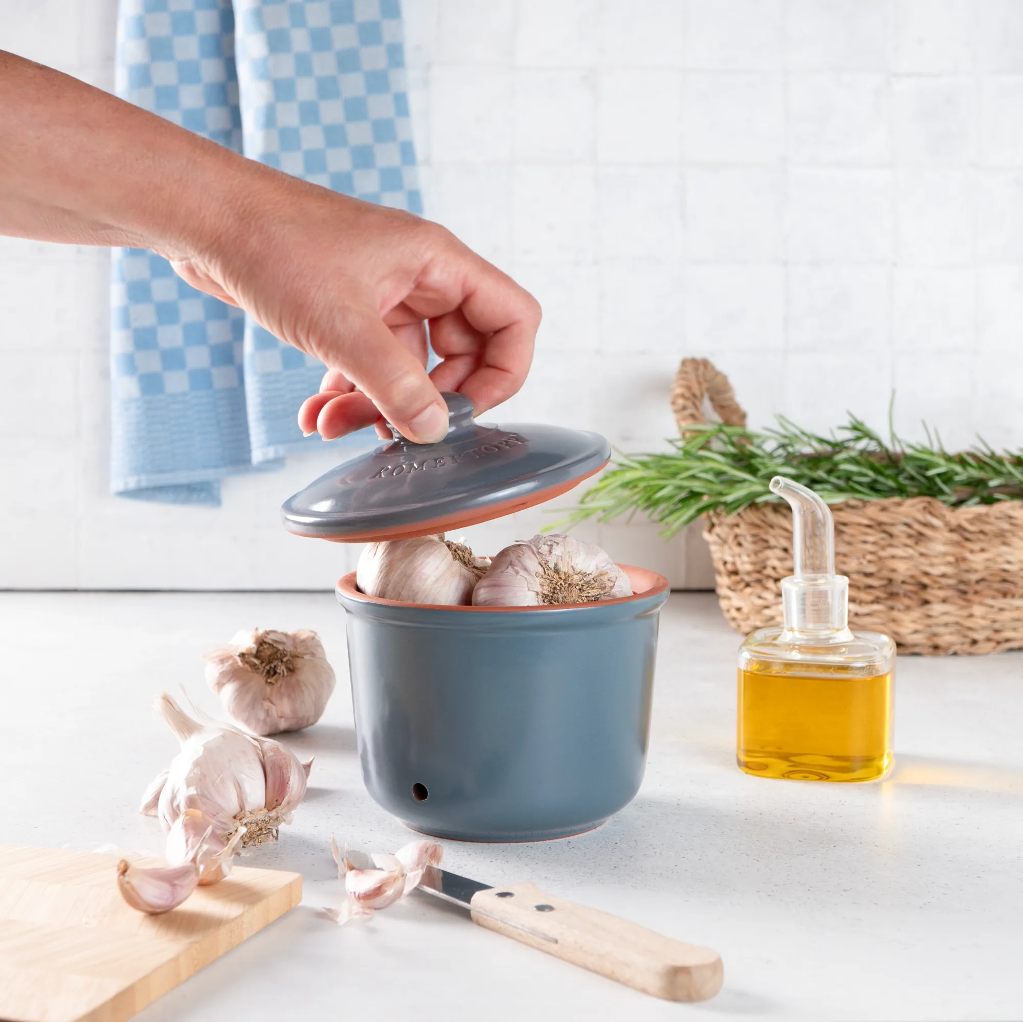 Römertopf Vorratstopf Set in Blaugrau – 2-teiliges Keramik-Set zur aromafrischen Aufbewahrung Römertopf Vorratstopf-Set in Blaugrau aus Keramik, bestehend aus drei unterschiedlich großen Töpfen mit Deckeln und belüfteten Seiten, stilvoll auf einer Küchenarbeitsplatte arrangiert.