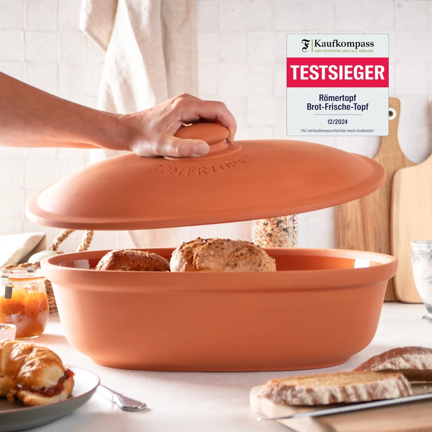 Römertopf Brottopf Maxi aus Terracotta – Frischetopf zur Brotaufbewahrung Römertopf Brottopf „Frischetopf Maxi“ aus Terrakotta mit Schriftzug „RÖMERTOPF“ auf dem Deckel, zylindrische Form, warme orangebraune Farbe, Deckel leicht gewölbt mit Griffknauf.