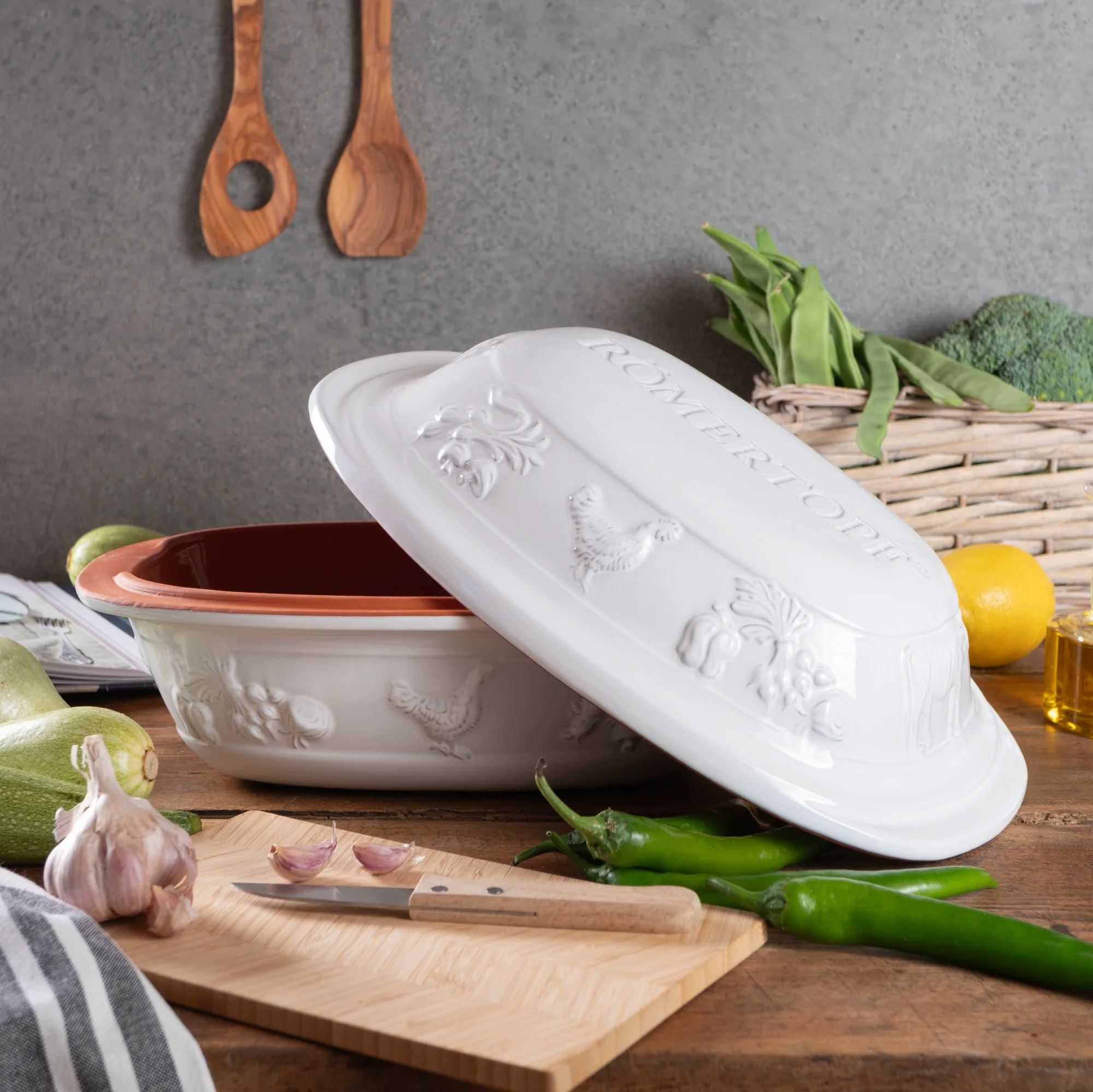 RÖMERTOPF Rustico Bräter für 4 Personen in Weiß – Keramik Schmortopf für schonendes Kochen Weißer Römertopf Rustico für vier Personen mit strukturiertem Deckel, seitlichen Griffmulden und ovaler Form, auf hellem Hintergrund dargestellt.