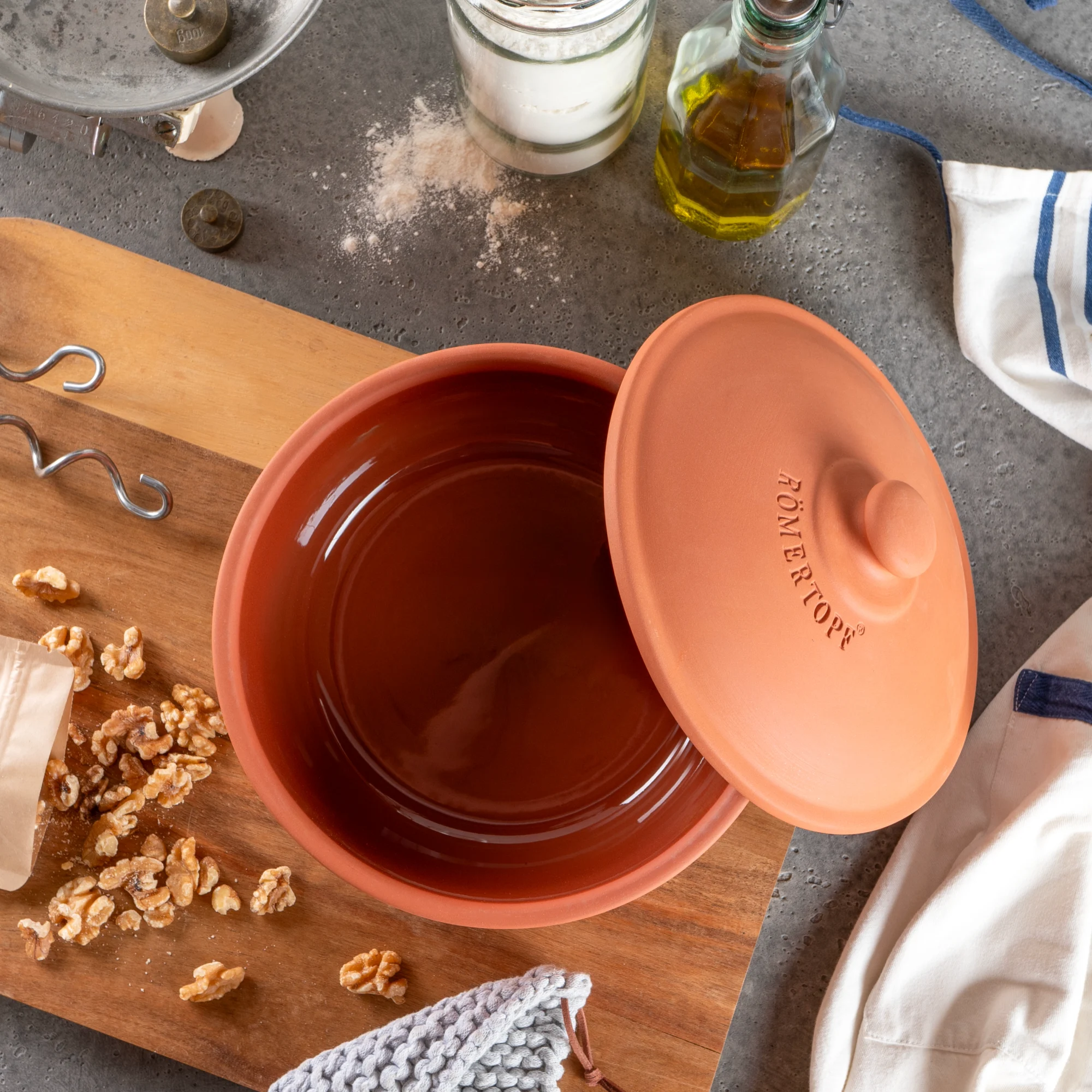Römertopf Brotbacktopf aus Terrakotta mit Deckel – Ideal für knuspriges, selbstgebackenes Brot Römertopf Brottopf aus Terrakotta mit Deckel, auf einem hellen Untergrund platziert; der Topf zeigt Prägungen und eignet sich zum traditionellen Brotbacken.