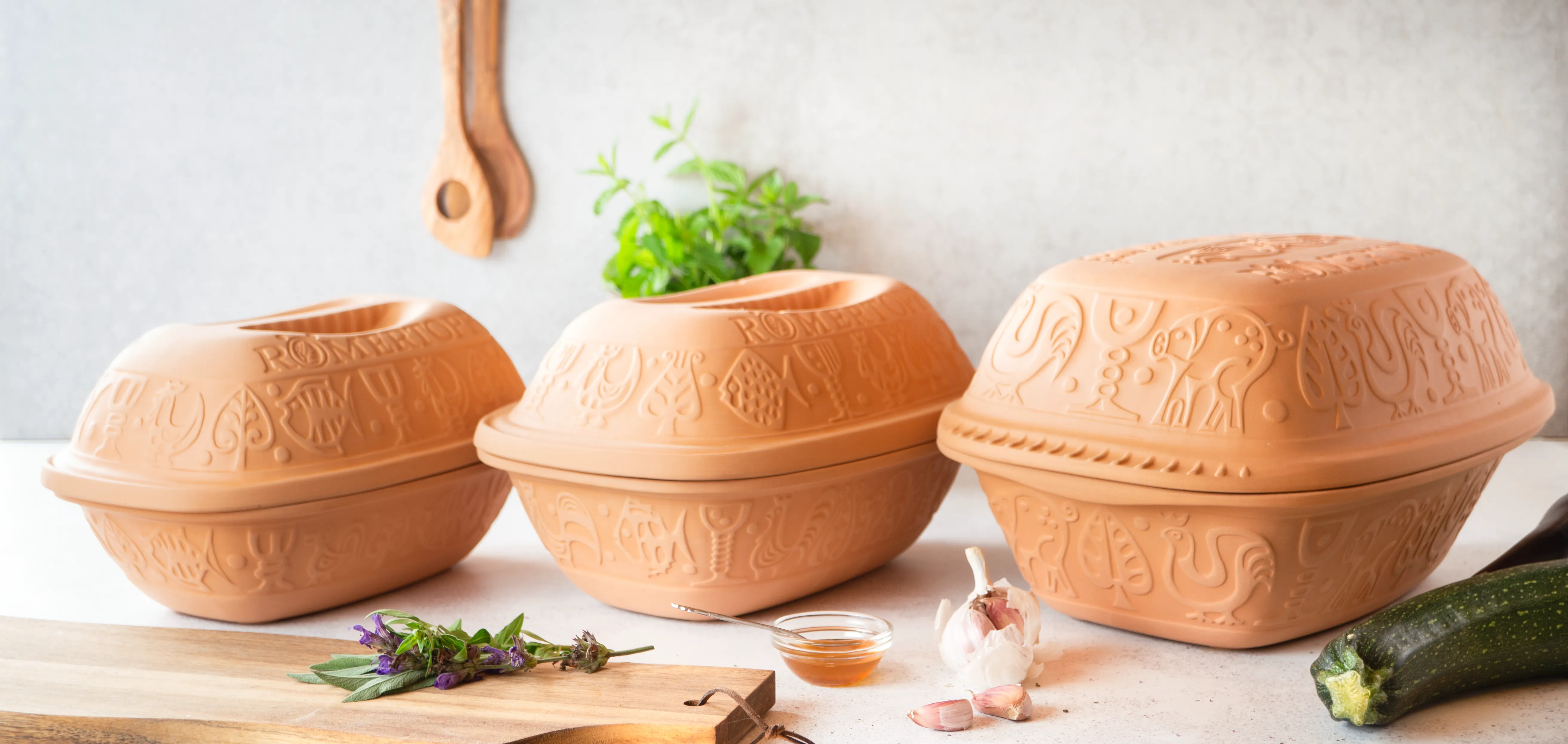 Römertopf Bräter aus Ton – Traditioneller Schmortopf für gesundes und fettfreies Kochen Römertopf-Bräter aus naturbelassenem Ton mit Deckel, rechteckige Form, steht auf hellem Untergrund – traditionelle Keramik für schonendes Garen im Ofen.