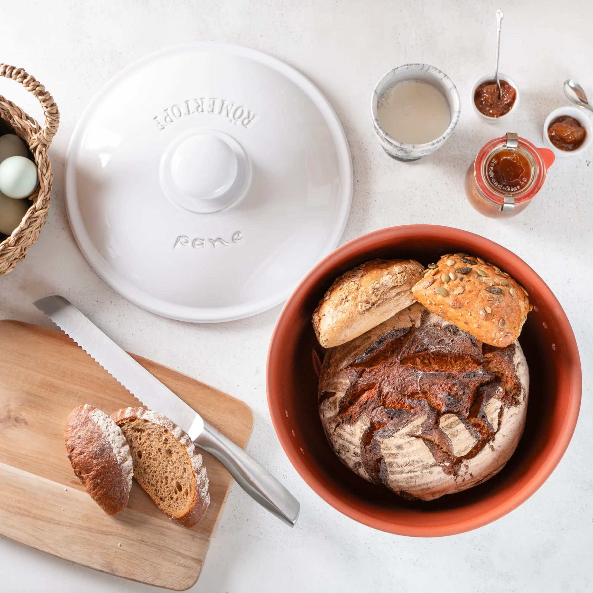 Römertopf Brottopf rund weiß – Frischetopf aus Keramik für lange Brotfrische Weißer runder Römertopf Brottopf mit Deckel, aus Keramik, steht auf weißem Hintergrund; der Topf hat seitliche Luftlöcher zur Belüftung und trägt die Prägung „RÖMERTOPF“ auf der Vorderseite.