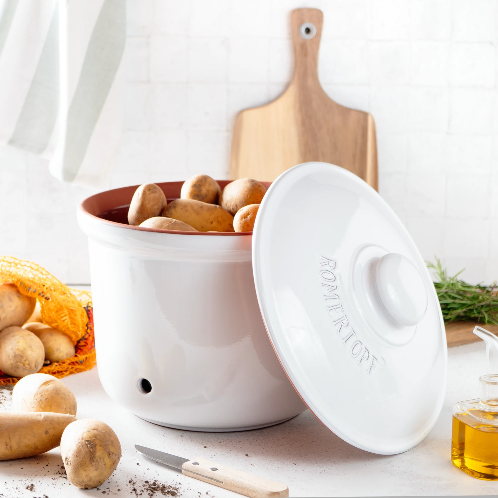 Römertopf Kartoffeltopf Maxi Plus Weiß – Kartoffel-Aufbewahrung aus Naturton für optimale Frische Weiß glasierter Römertopf-Kartoffeltopf in XL-Größe mit Deckel, stehend auf einem hellen Untergrund; seitlich ist das eingefräste "Römertopf"-Logo sichtbar.