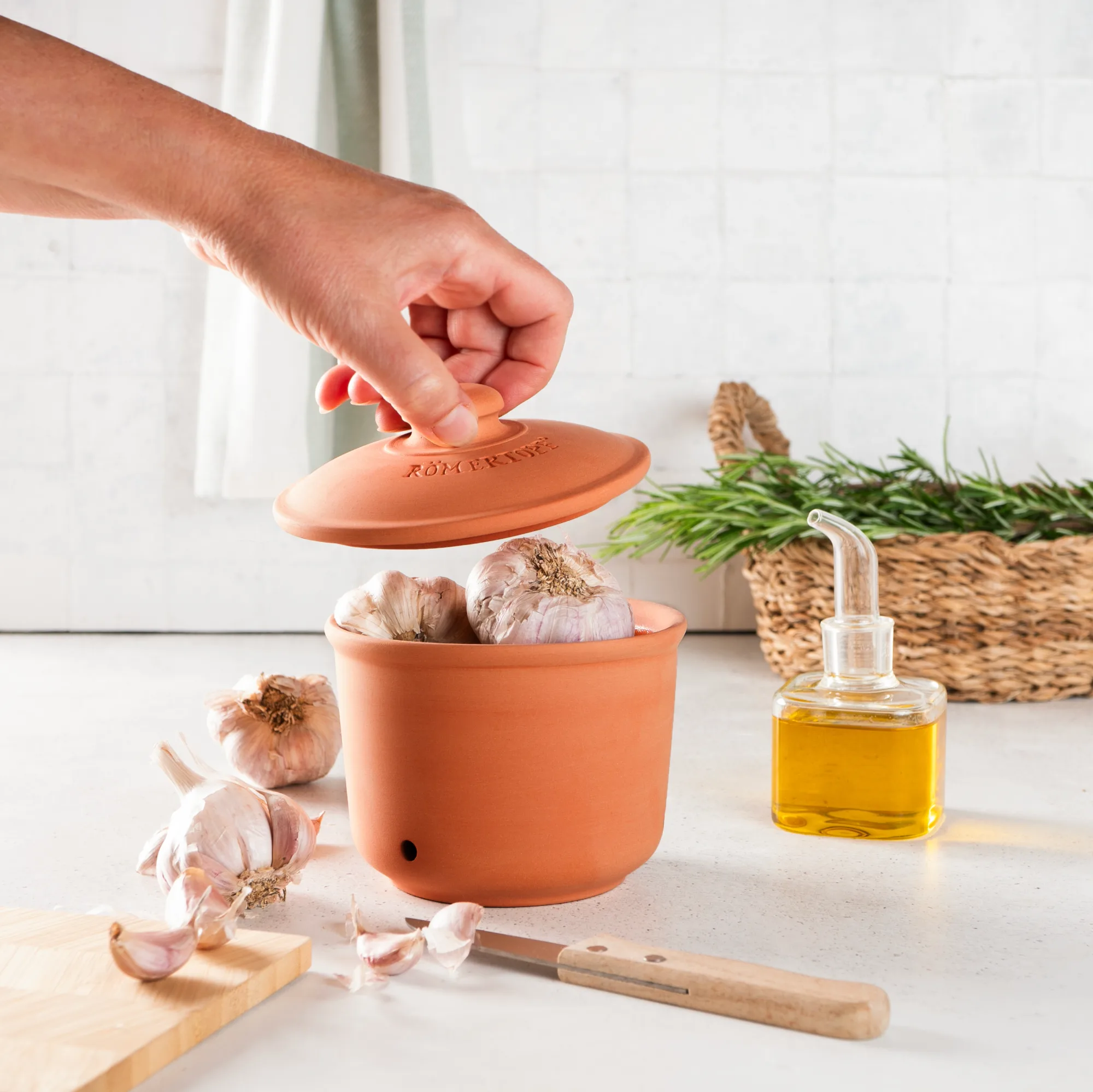 Römertopf Vorratstopf Set aus Terrakotta – 3-teiliges Aufbewahrungs-Set für Küche und Vorratsschrank Zwei runde Vorratstöpfe aus naturfarbener Terrakotta mit passendem Deckel, auf braunem Untergrund; ein Topf ist größer und mit „ZWIEBELN“ beschriftet, der kleinere mit „KNOBLAUCH“.