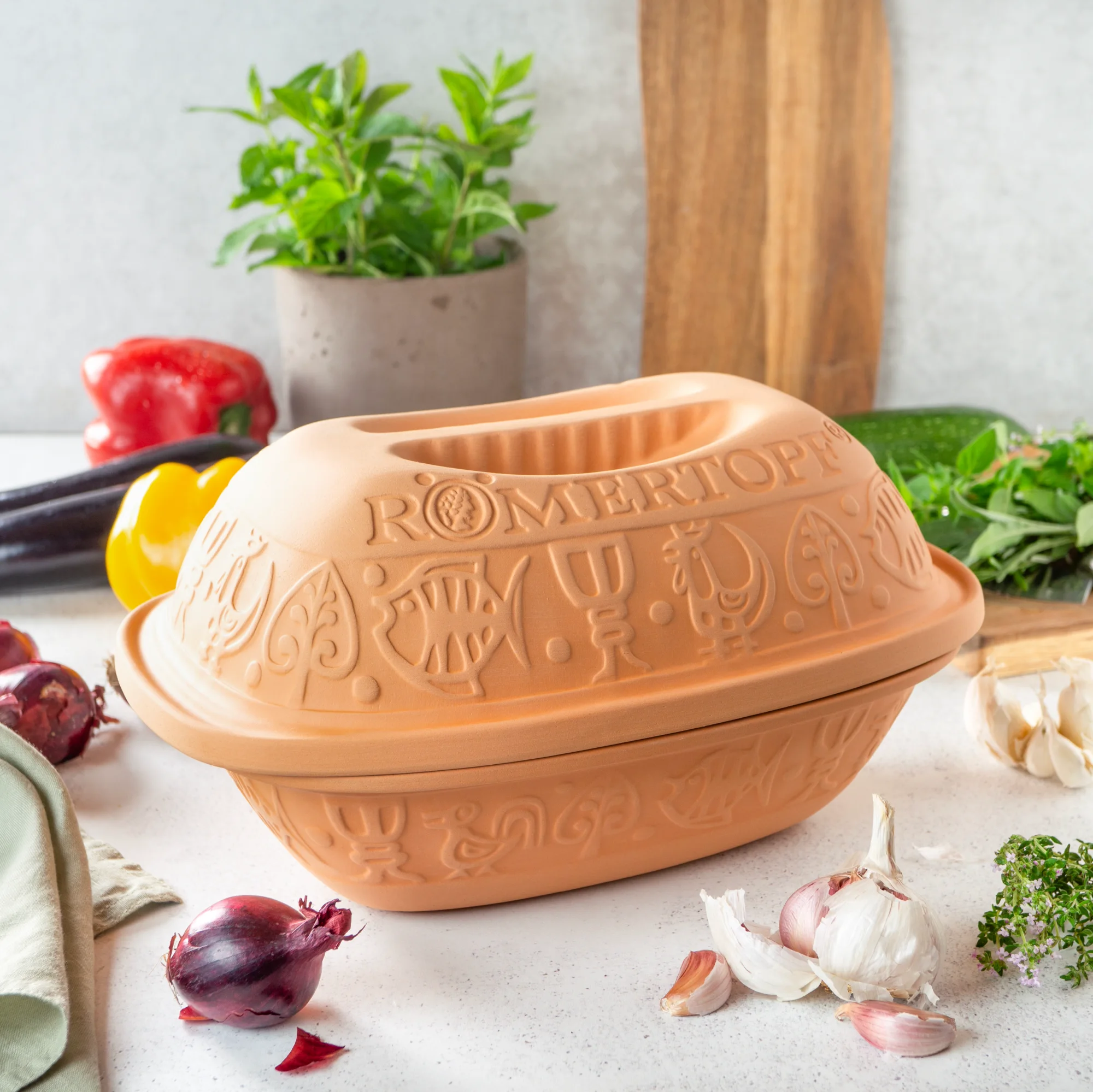 Römertopf Bräter klassisch für 2 Personen aus Naturton – Schmortopf mit Deckel für gesundes Kochen Römertopf Bräter aus naturfarbenem Ton mit Deckel, klassisch geformt, für zwei Personen, auf weißem Hintergrund.
