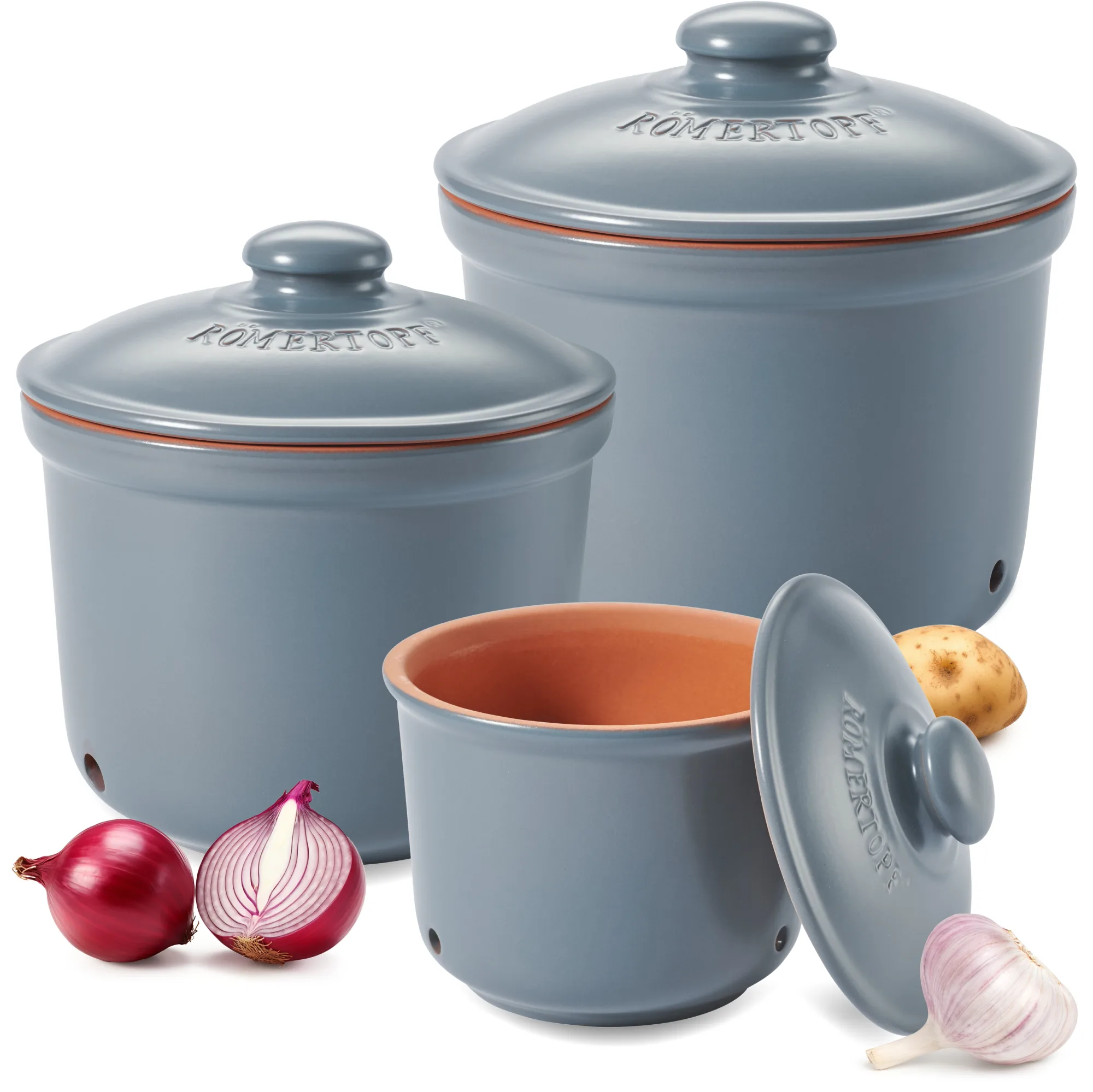 Römertopf Vorratstopf Set aus Keramik in Blaugrau – 3-teiliges Aufbewahrungsset für Küche Vorratstopf-Set aus Keramik in Blaugrau, bestehend aus drei unterschiedlich großen Töpfen mit Deckel, jeweils mit Lüftungslöchern und beschriftet für Kartoffeln, Zwiebeln und Knoblauch; auf heller Oberfläche arrangiert.