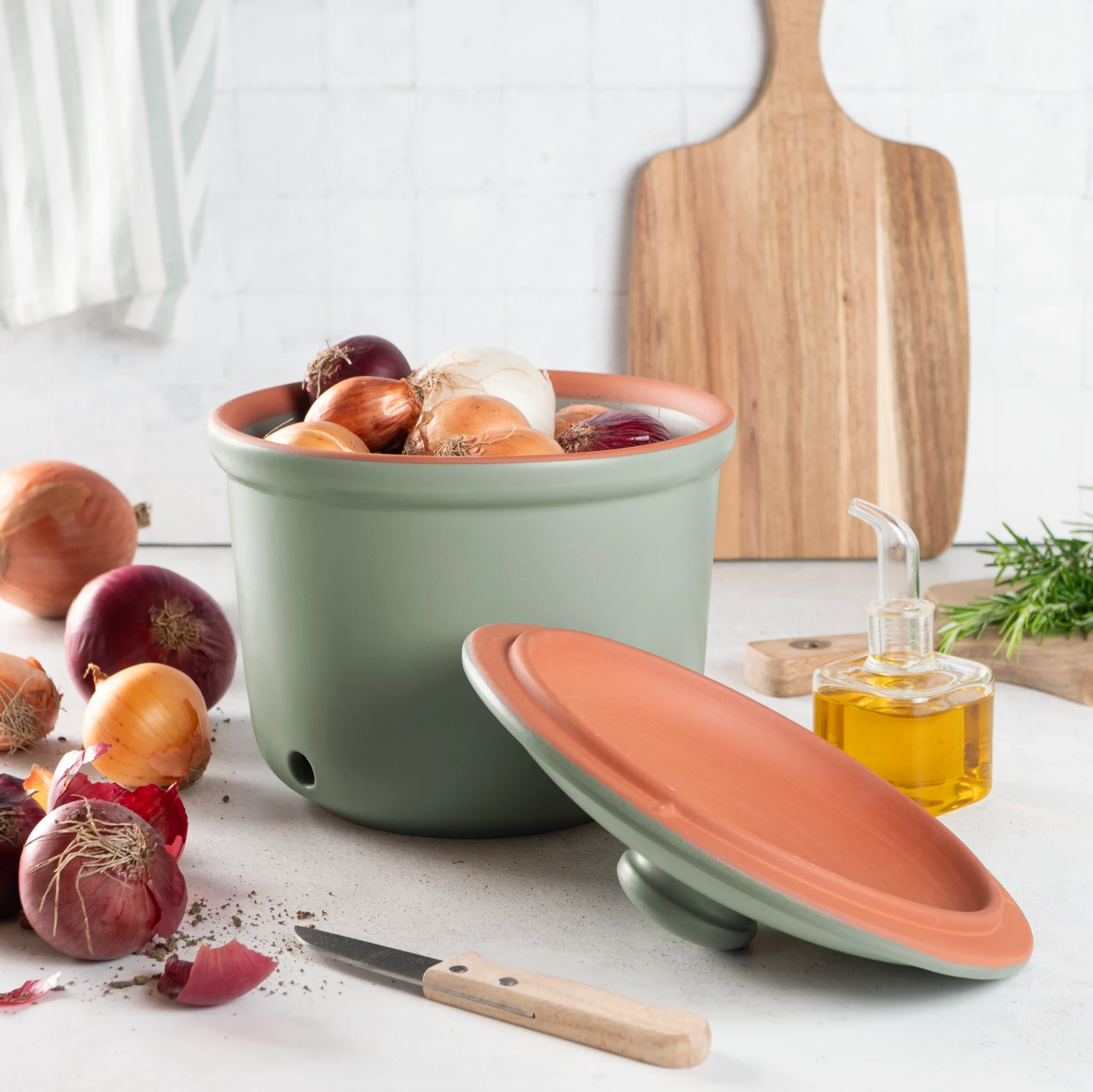 Römertopf Zwiebel-Frischetopf aus Keramik in Grün – Ideal zur Aufbewahrung von Zwiebeln Grüner Römertopf Frischhaltetopf für Zwiebeln mit atmungsaktivem Deckel, hergestellt aus unglasierter Keramik, auf weißem Hintergrund.
