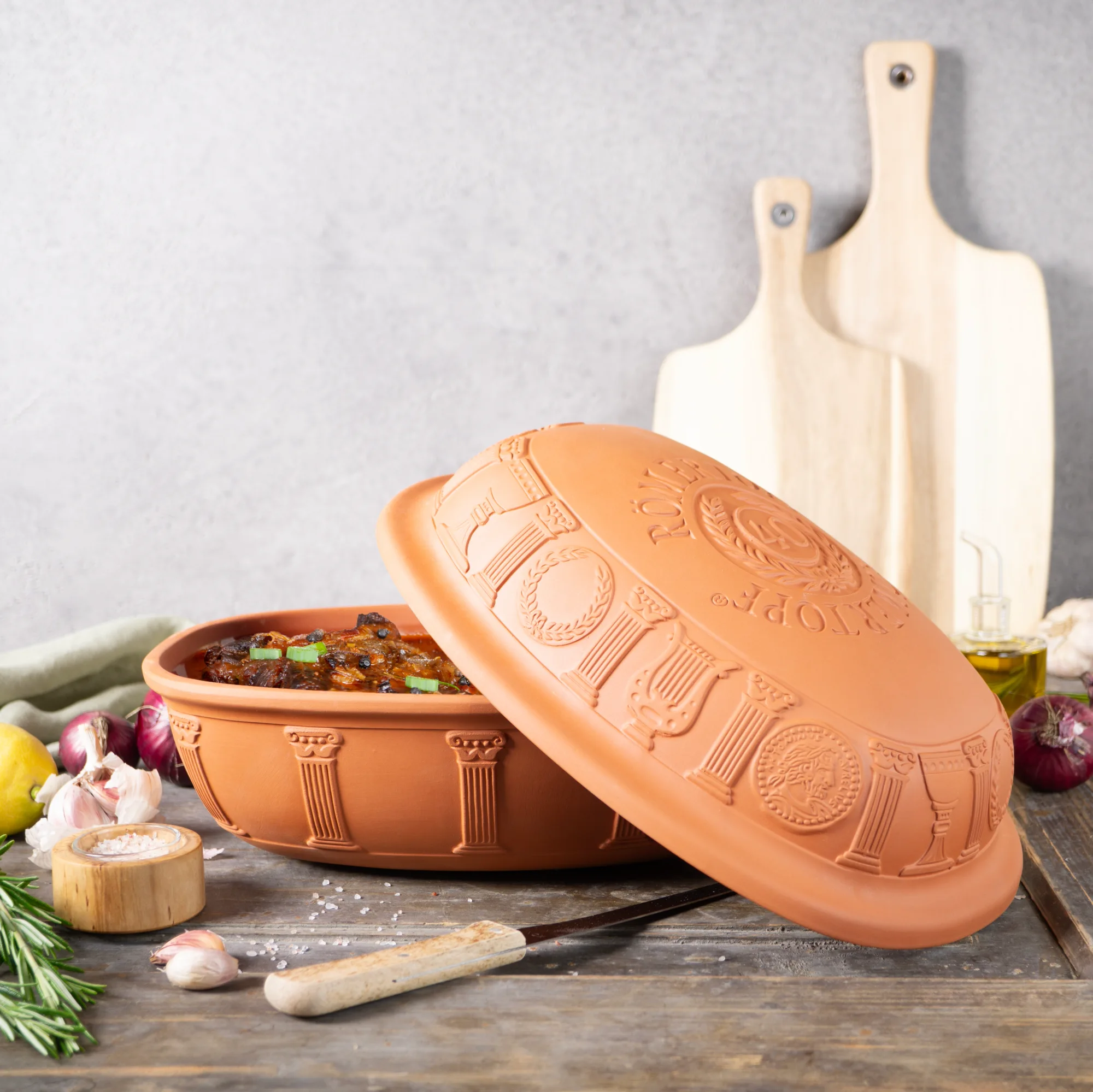 Römertopf Bräter Jubiläumsedition – 40 Jahre Klassiker aus Naturton Runder Römertopf-Bräter mit Deckel aus naturfarbenem Ton, seitlich graviert mit der Aufschrift „40 Jahre“, auf weißem Hintergrund.