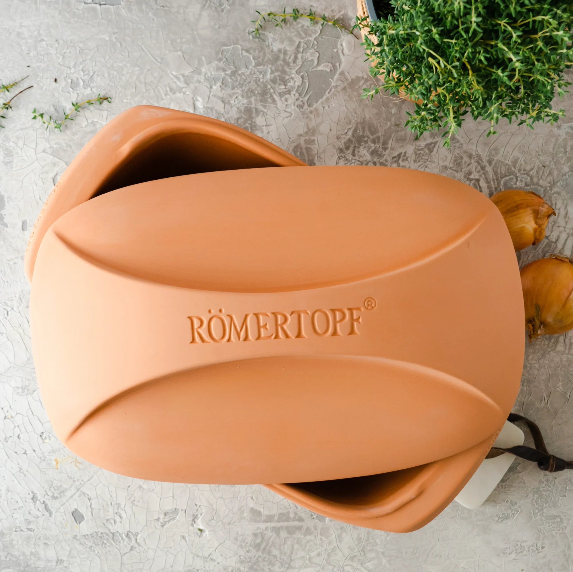 Römertopf Bräter Culinario aus Terrakotta – traditioneller Tontopf für fettfreies, aromatisches Garen RÖMERTOPF Bräter "Culinario" aus Terrakotta mit Deckel, rechteckige Form, naturfarbene Oberfläche, auf weißem Hintergrund.