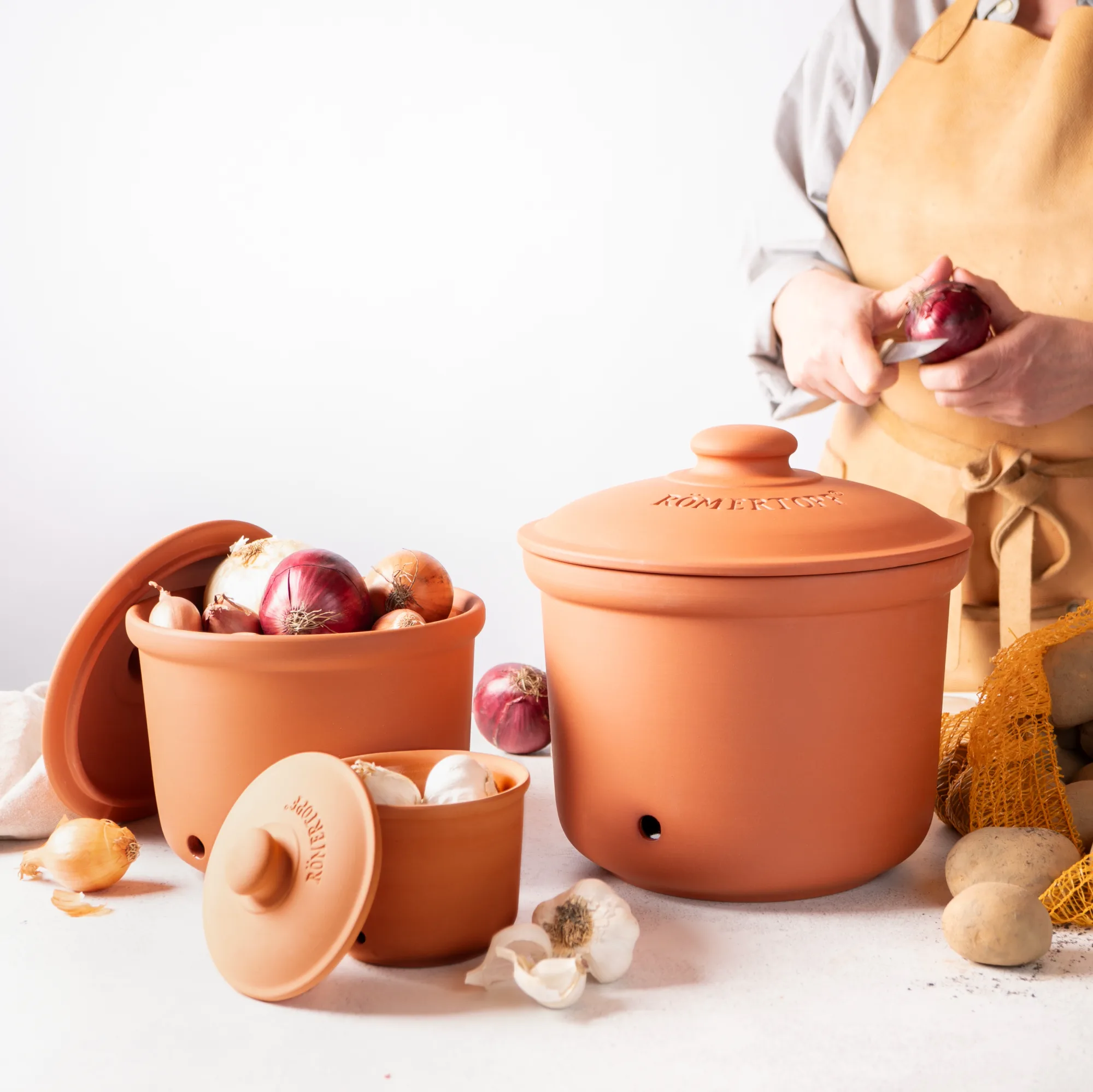 Römertopf Vorratstopf-Set aus Terrakotta – 3-teiliges Keramik-Aufbewahrungsset für Küche Zweiteiliges Vorratstopf-Set aus Terrakotta in Naturfarbe, bestehend aus zwei unterschiedlich großen Töpfen mit Deckeln, beide mit seitlichen Griffmulden und dem Schriftzug „VorratsTopf“ auf der Vorderseite, vor neutralem Hintergrund.