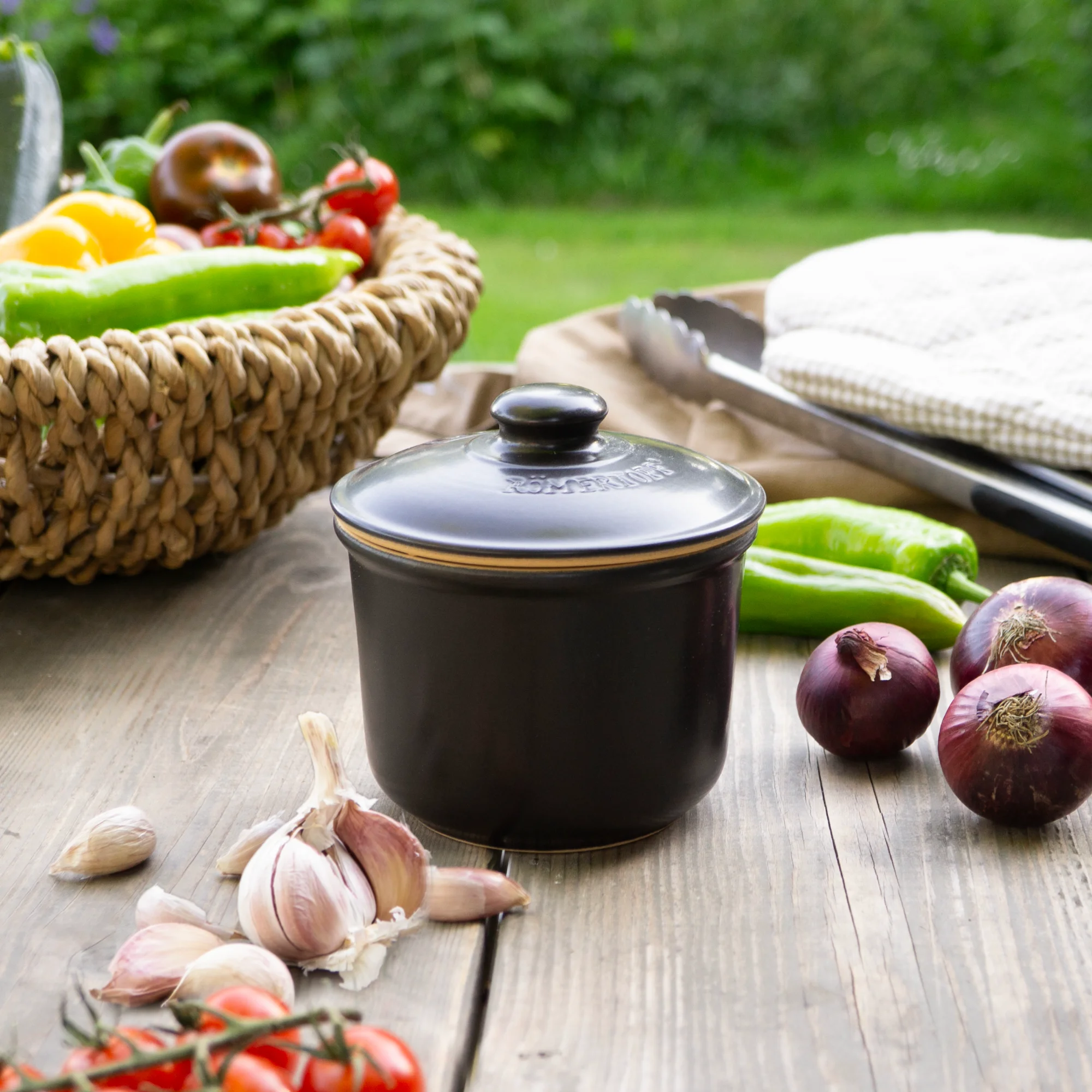 Römertopf Mini Schmortopf aus Keramik – ideal für kleine Portionen und schonendes Kochen Kleiner, ovaler Römertopf aus naturfarbenem Ton mit Deckel, auf einer weißen Fläche präsentiert. Der Deckel trägt das eingeprägte Römertopf-Logo.