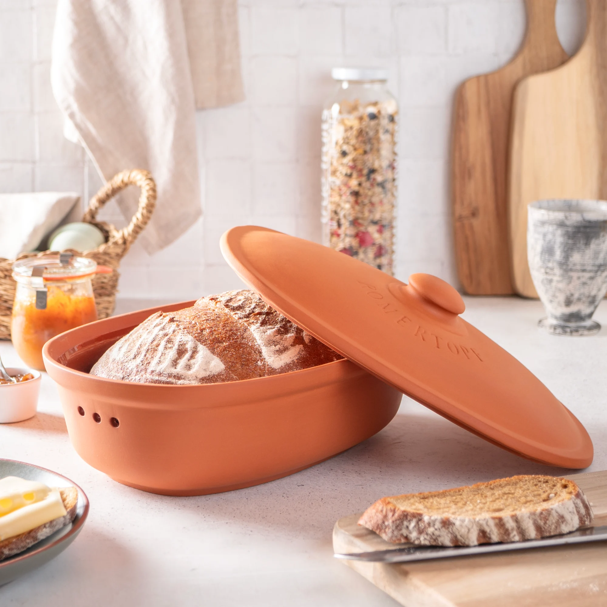 RÖMERTOPF Brottopf Frischetopf Medi aus Terracotta – Atmungsaktive Aufbewahrung für frisches Brot RÖMERTOPF Brottopf aus Terrakotta in mittelgroßer Ausführung, mit rundem Deckel und seitlichen Grifföffnungen, stehend auf heller Oberfläche.
