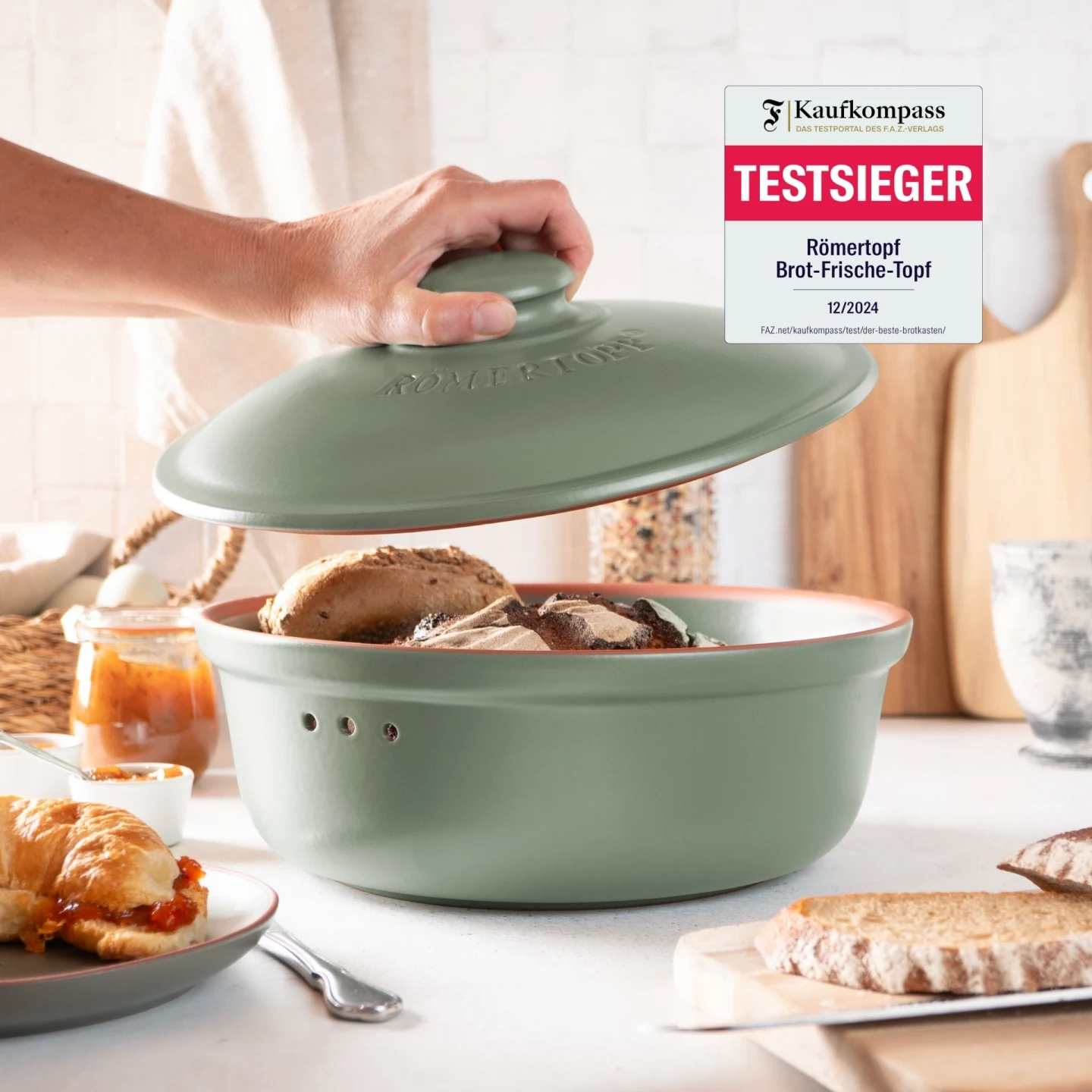 Römertopf Brottopf rund grün – Keramik Frischetopf zur Brotaufbewahrung Runder Brottopf aus grün glasierter Keramik mit Deckel, hergestellt von Römertopf, auf hellem Untergrund stehend.