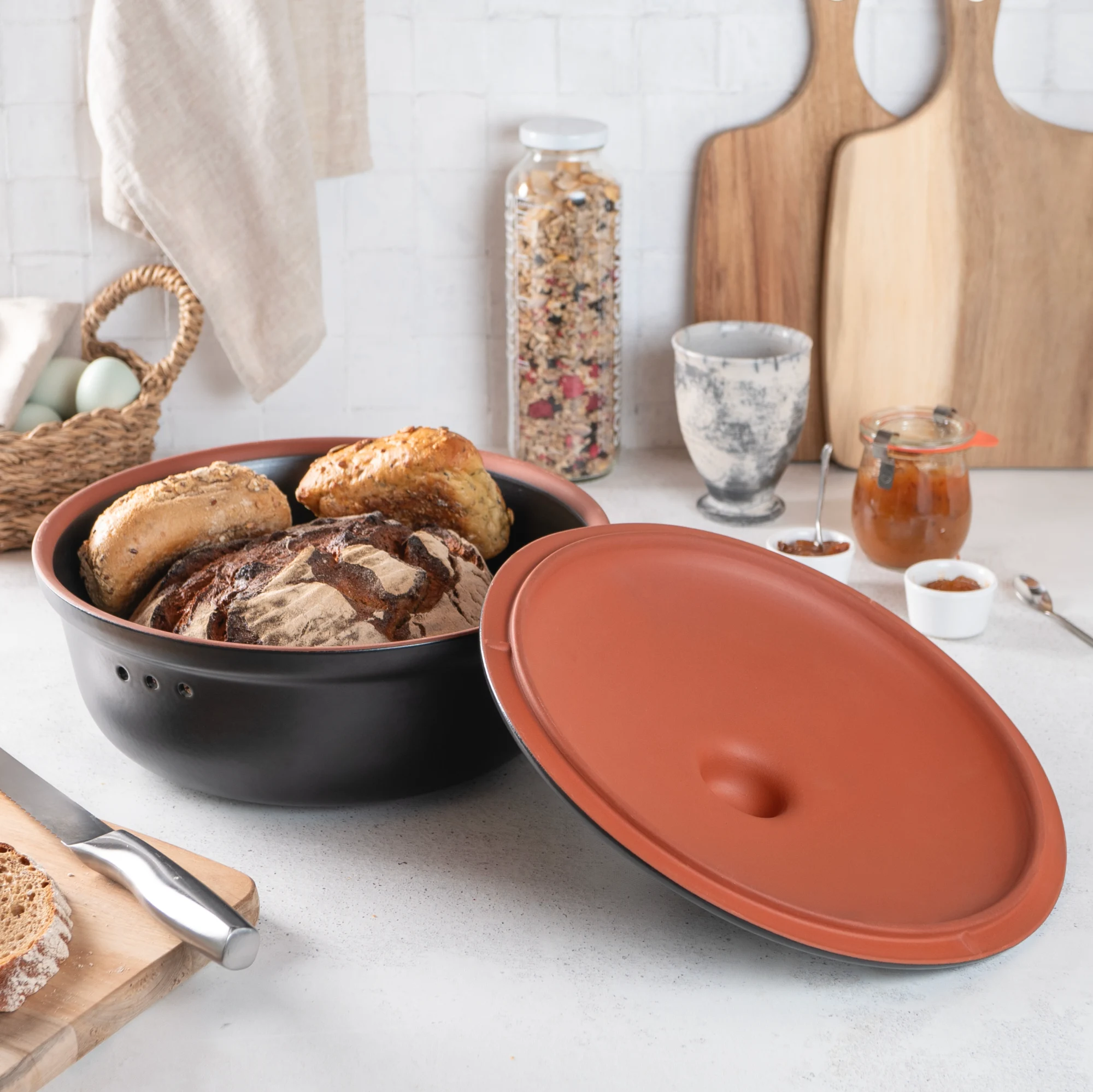 Römertopf Brottopf rund in Schwarz – Frischetopf aus Naturton zur Brotaufbewahrung Runder, schwarzer Römertopf Brottopf mit Deckel aus Keramik, stehend auf hellem Untergrund.