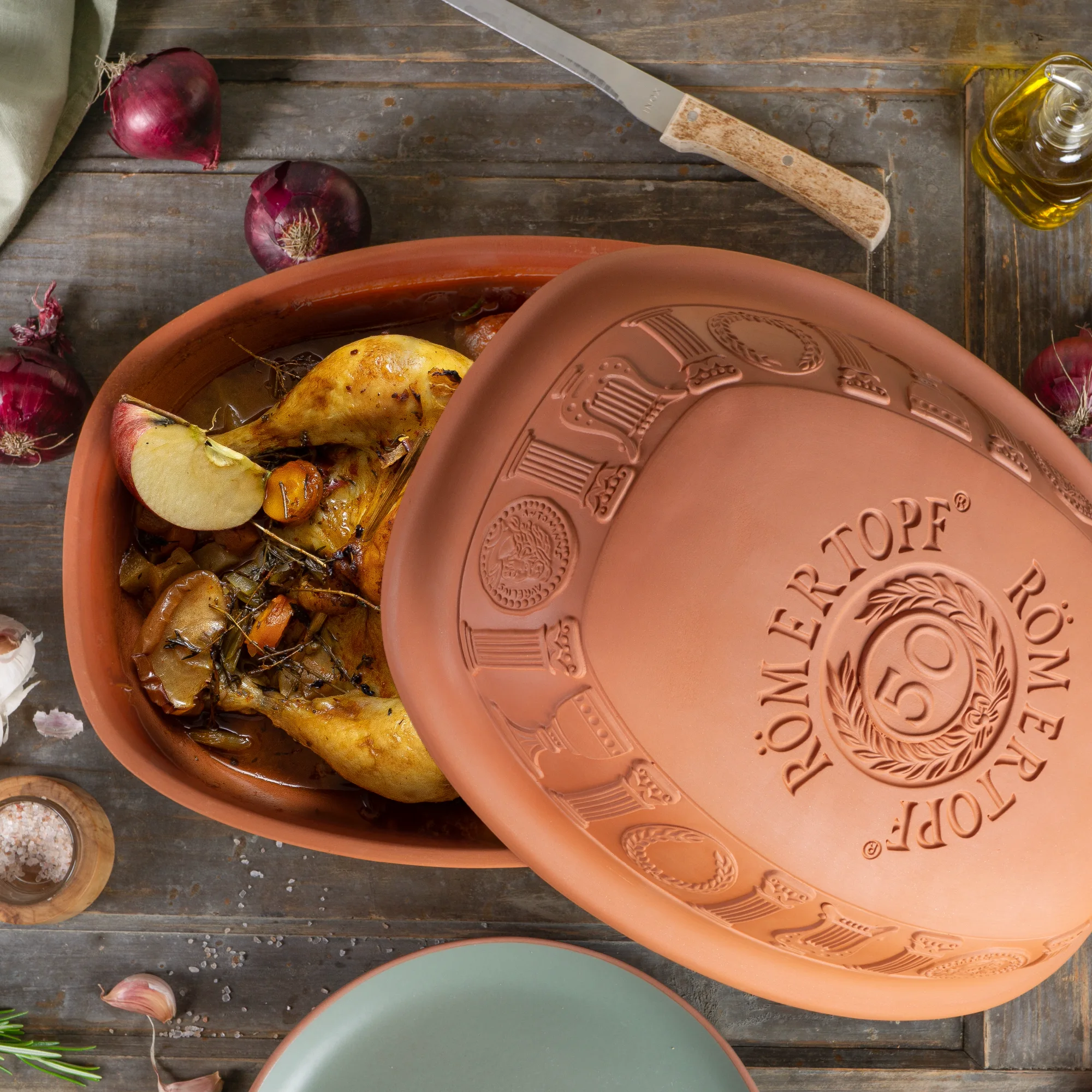 Römertopf Bräter klassisch für Backofen – 50 Jahre Jubiläumsedition – Keramik Schmortopf mit Deckel Rechteckiger Römertopf-Bräter aus Naturton mit Deckel, in Beige mit geprägtem Relief „50 Jahre Römertopf“, auf weißem Hintergrund.
