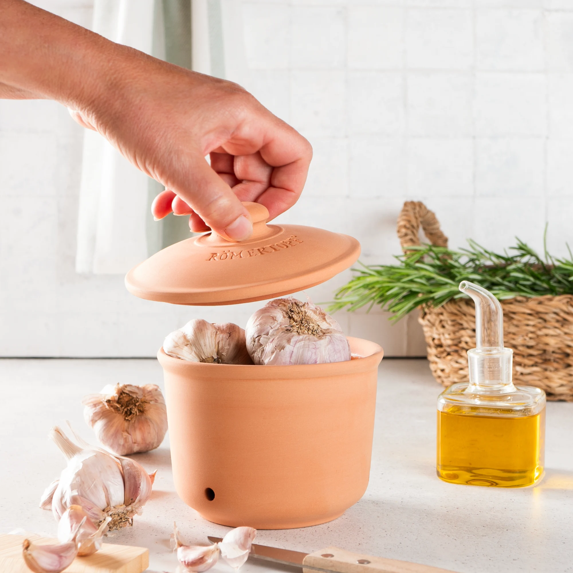 Römertopf Frischetopf Maxi Zwiebeltopf aus Terracotta – dekorativer Vorratsbehälter zur optimalen Lagerung von Zwiebeln Großer runder Zwiebeltopf aus Terrakotta mit Deckel, natürlicher rötlich-brauner Farbe, luftdurchlässige Belüftungslöcher und Prägung „RÖMERTOPF“ auf der Vorderseite, vor weißem Hintergrund.