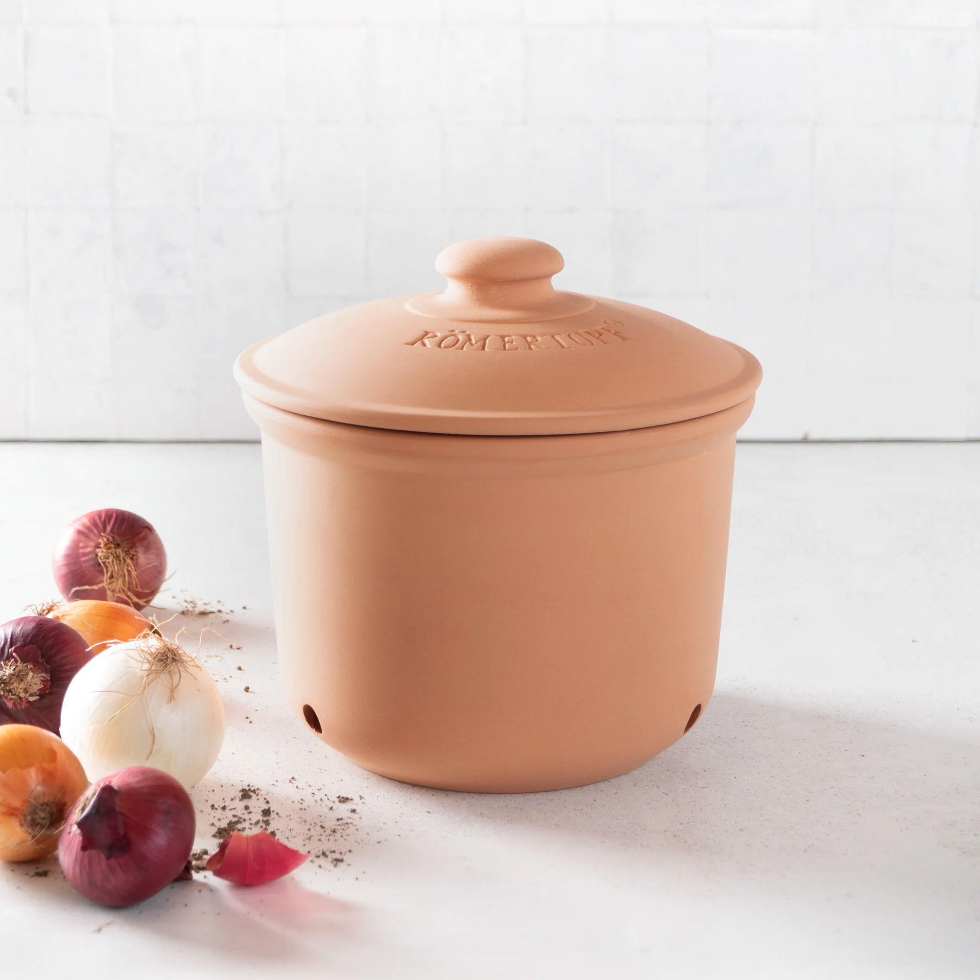 Römertopf Zwiebeltopf Maxi aus Terrakotta zur luftdichten Aufbewahrung von Zwiebeln Großer Zwiebeltopf aus Terrakotta mit seitlichen Luftlöchern, Deckel und „RÖMERTOPF“-Prägung, stehend auf weißem Hintergrund.