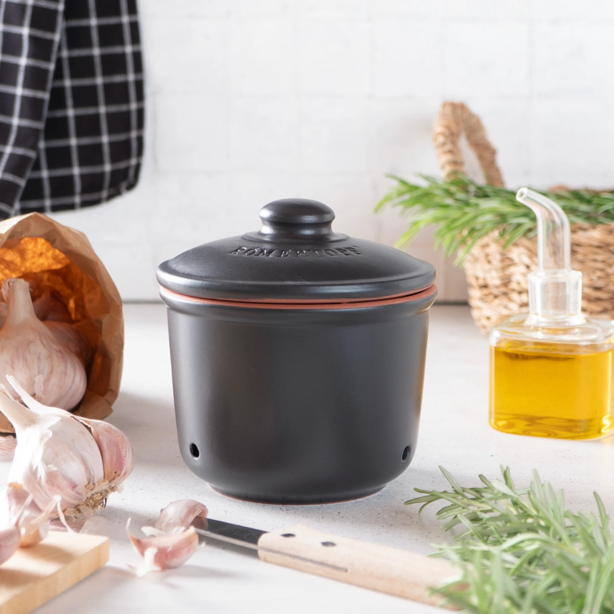 Römertopf Knoblauch-Frischetopf Mini in Schwarz – Stilvolle Vorratsdose zur Aufbewahrung von Knoblauch Schwarzer, kleiner Römertopf-Frischetopf für Knoblauch mit Deckel und seitlichen Lüftungslöchern, auf weißem Hintergrund.