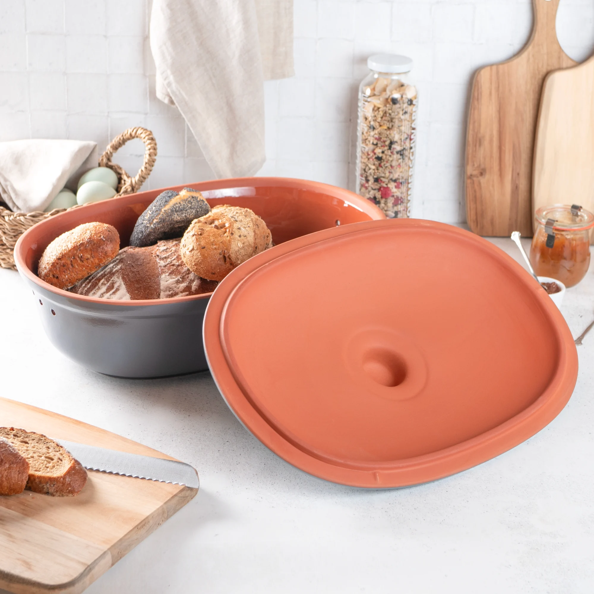 Römertopf Brottopf blaugrau aus Keramik mit Deckel – atmungsaktive Aufbewahrung für frisches Brot Römertopf Brottopf in Blaugrau mit Deckel, ovaler Form und Lüftungslöchern für optimale Brotaufbewahrung, auf weißem Untergrund.