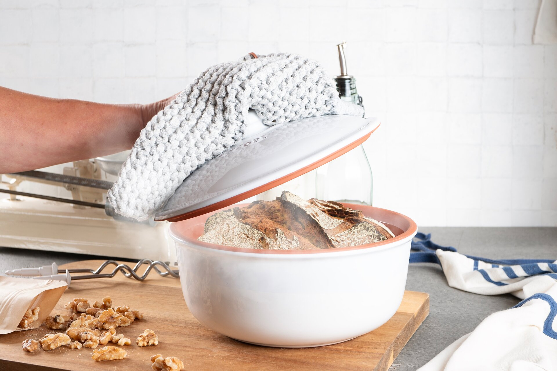 Barrierefreie Römertopf Brotbackformen aus Ton – nachhaltig und naturliebend backen Verschiedene Römertopf-Brotbackformen aus Ton in unterschiedlichen Größen und Formen, aufgereiht auf einem Holztisch vor neutralem Hintergrund.