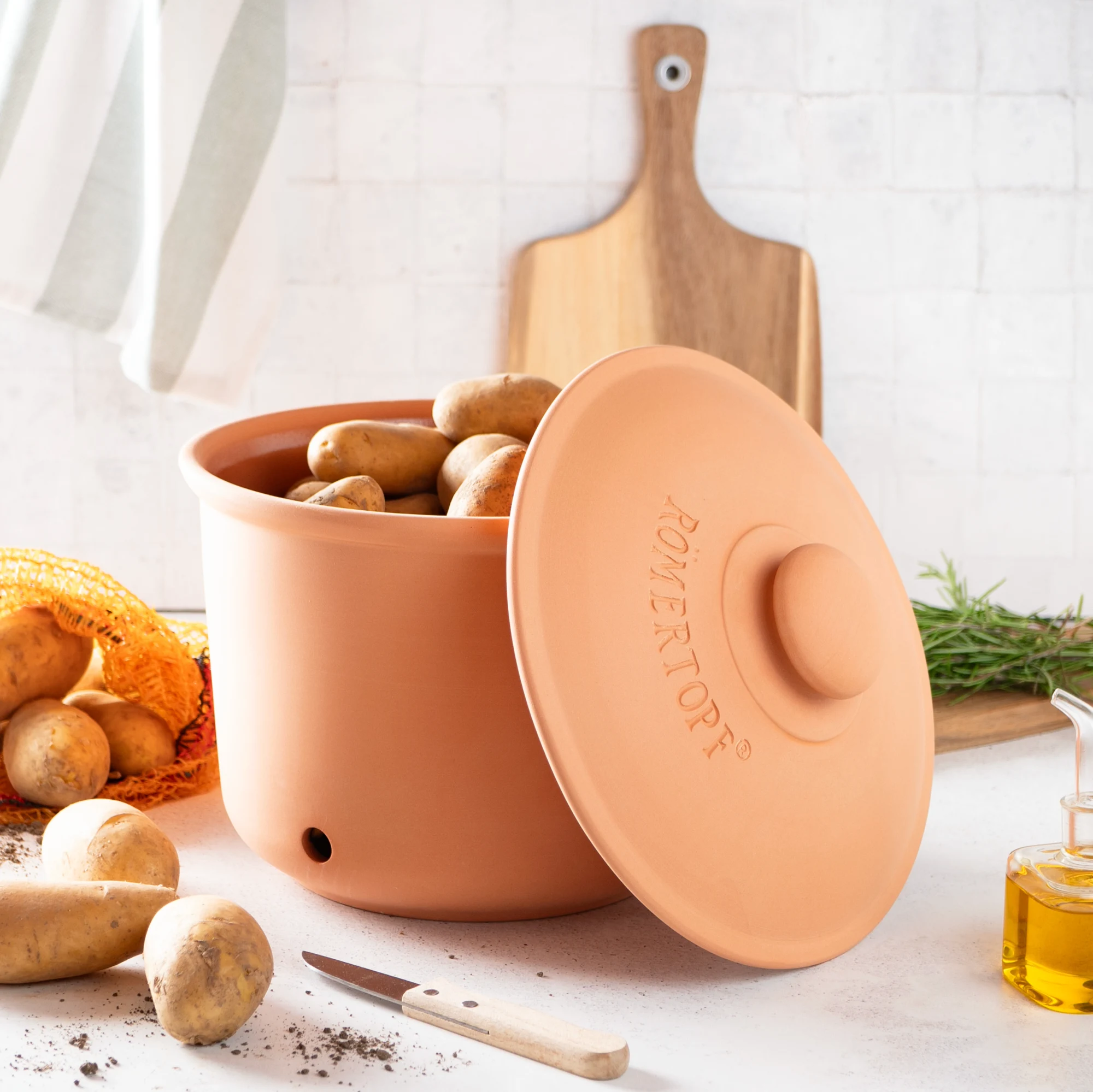 Römertopf Kartoffeltopf Maxi Plus aus Terrakotta mit Deckel – atmungsaktiv zur optimalen Kartoffelaufbewahrung Römertopf Kartoffeltopf Maxi Plus aus Terrakotta mit Deckel, seitlich belüftet, auf weißem Hintergrund – geeignet zur luftdurchlässigen Lagerung von Kartoffeln.