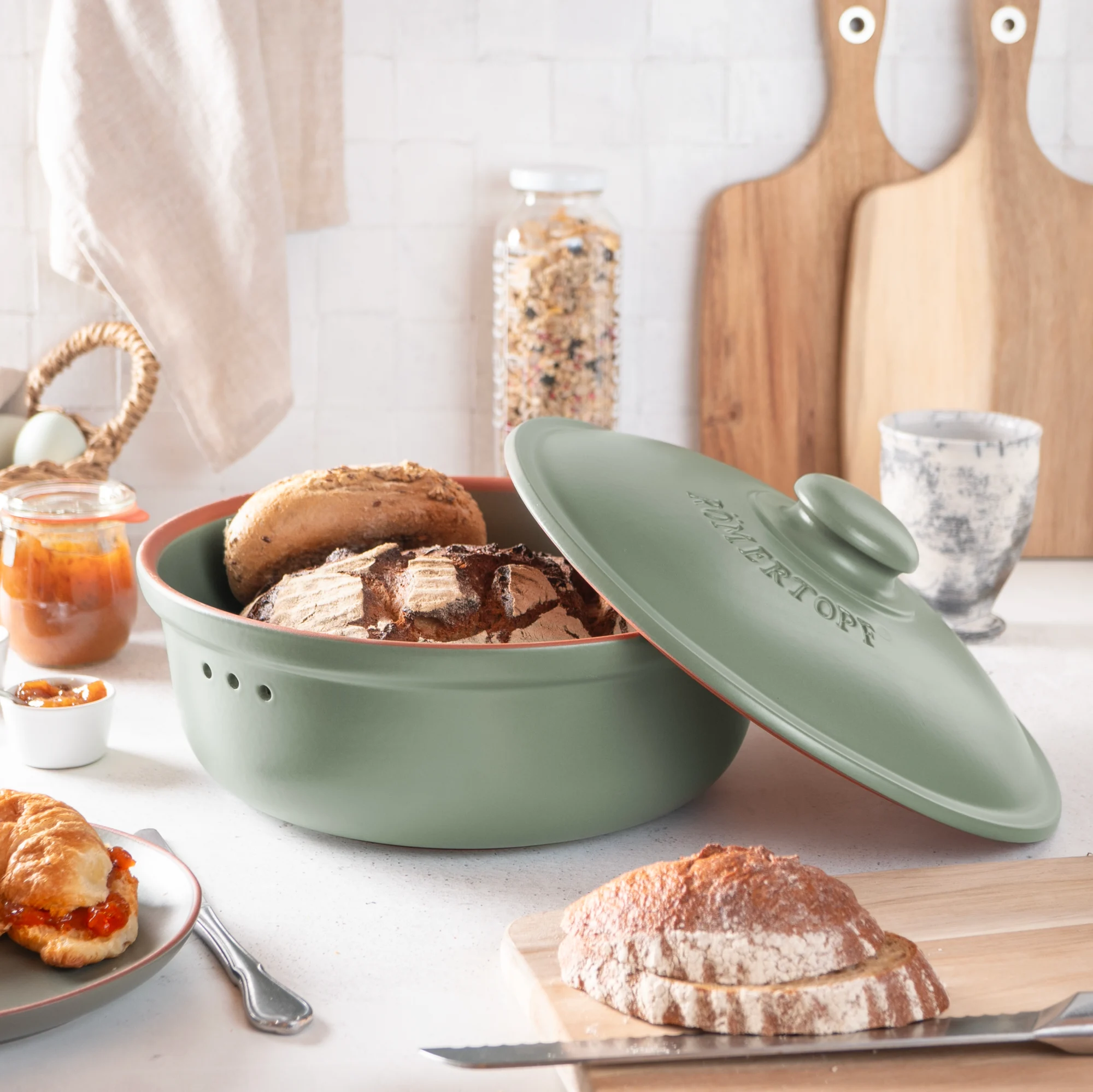 RÖMERTOPF Brottopf Frischetopf rund grün – Keramik Brotaufbewahrung für langanhaltende Frische Runder grüner Römertopf Brottopf mit passendem Deckel, seitlicher Aufschrift „RÖMERTOPF“ und kleiner Belüftungsöffnung, auf hellem Hintergrund.