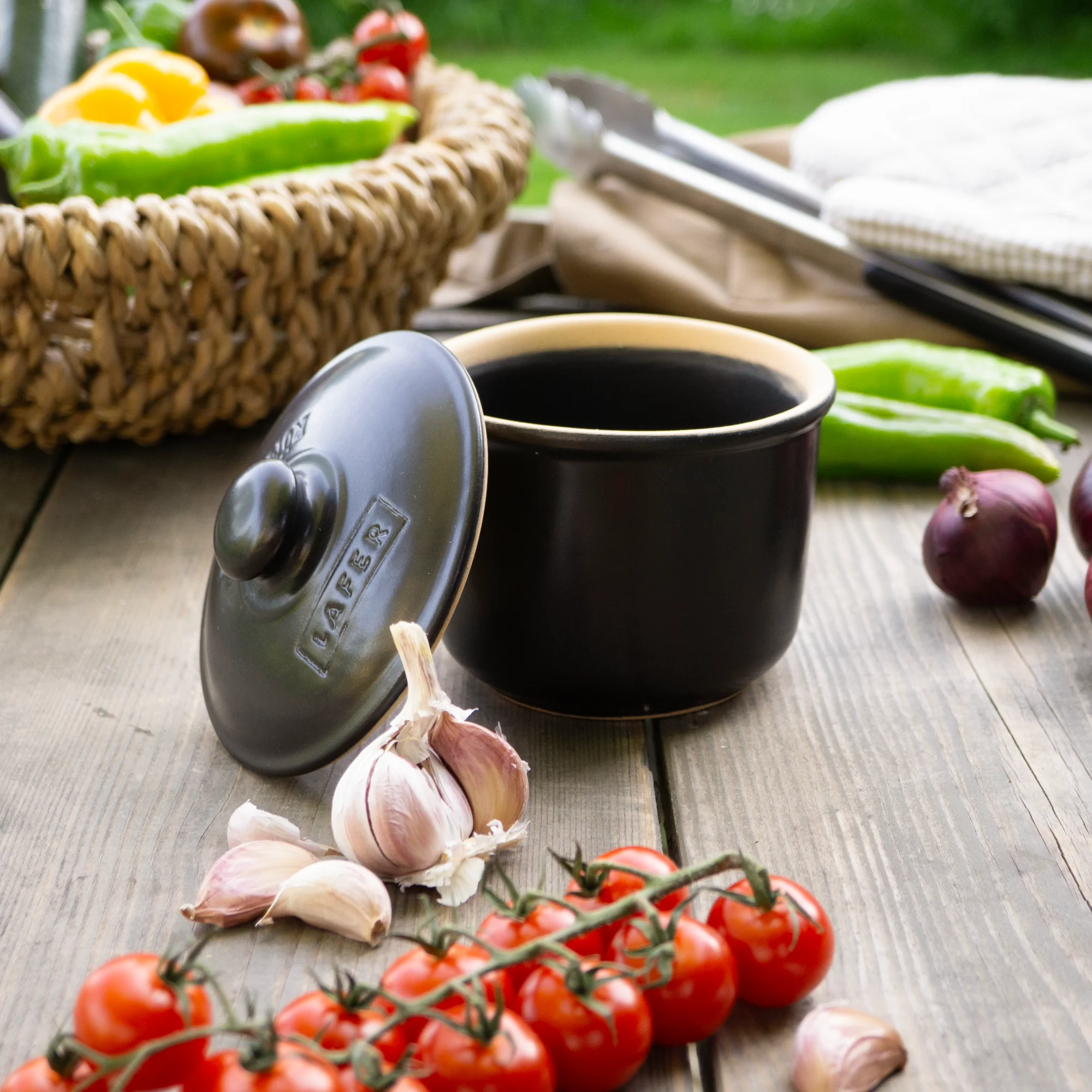 Römertopf Mini Schmortopf aus Ton mit Deckel – Ideal für kleine Portionen und fettfreies Garen Kleiner Römertopf-Schmortopf aus naturfarbenem Ton mit Deckel, auf Holztisch platziert; im Hintergrund Kräuter, Knoblauch und weitere Zutaten.