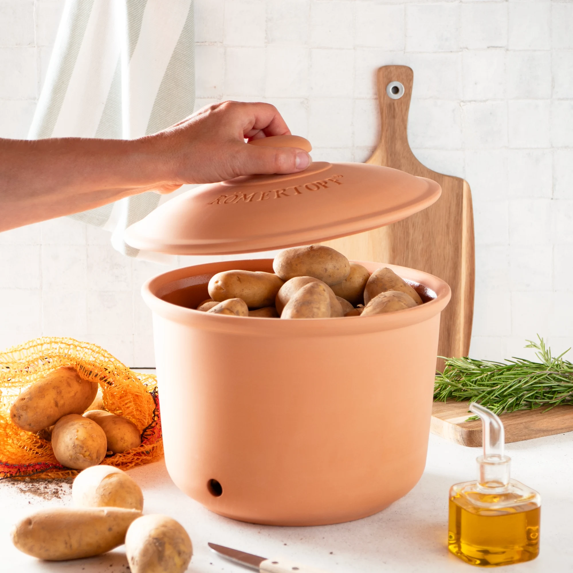 Römertopf Kartoffeltopf Maxi Plus aus naturbelassener Terrakotta mit Deckel Römertopf Kartoffeltopf Maxi Plus aus Terrakotta mit Deckel, auf glattem Untergrund stehend; der Topf zeigt eine klassische runde Form mit dekorativem Muster und ist für die Aufbewahrung von Kartoffeln gestaltet.