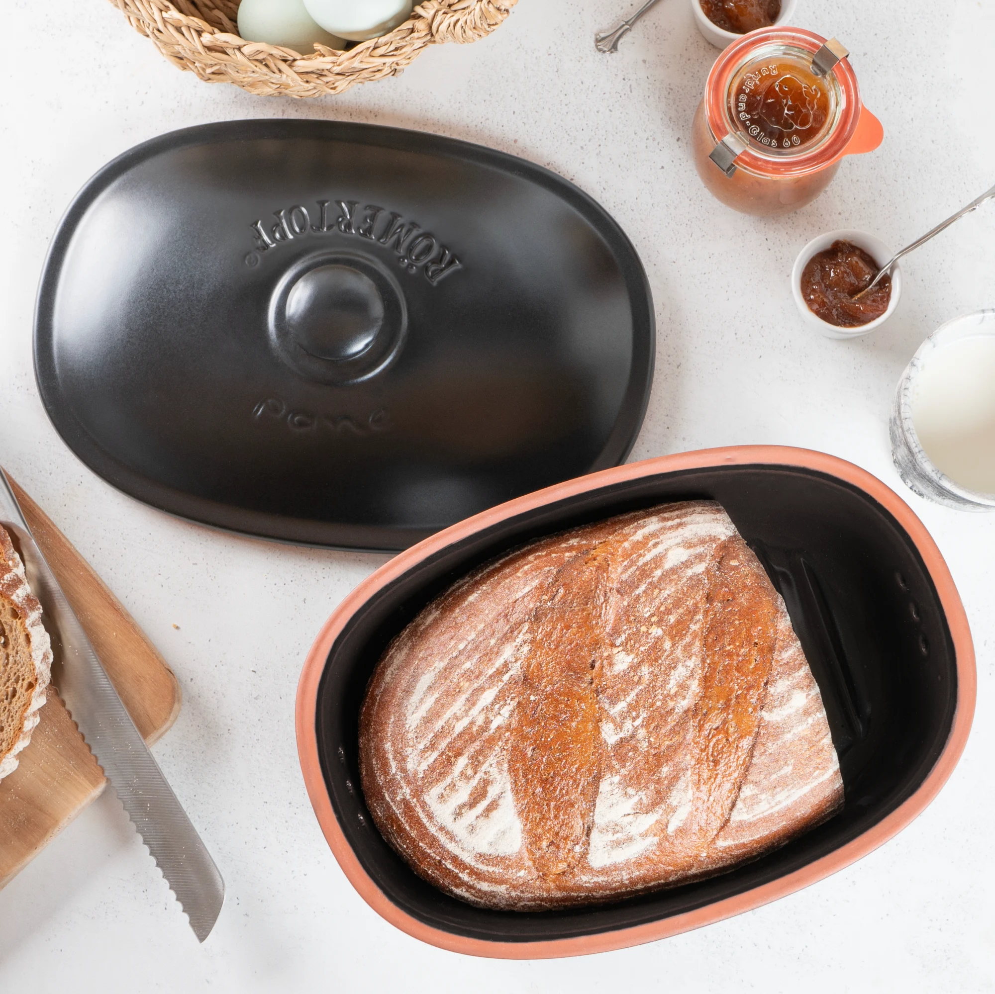 Römertopf Frische-Brottopf in Schwarz aus Naturkeramik – Luftdichter Brottopf zur langen Frischhaltung von Brot Runder Brottopf aus schwarzer Keramik mit hellem Deckel, darauf das eingeprägte Wort „BROT“ und seitliche Griffmulden; der Topf steht auf einer ebenen Oberfläche vor neutralem Hintergrund.