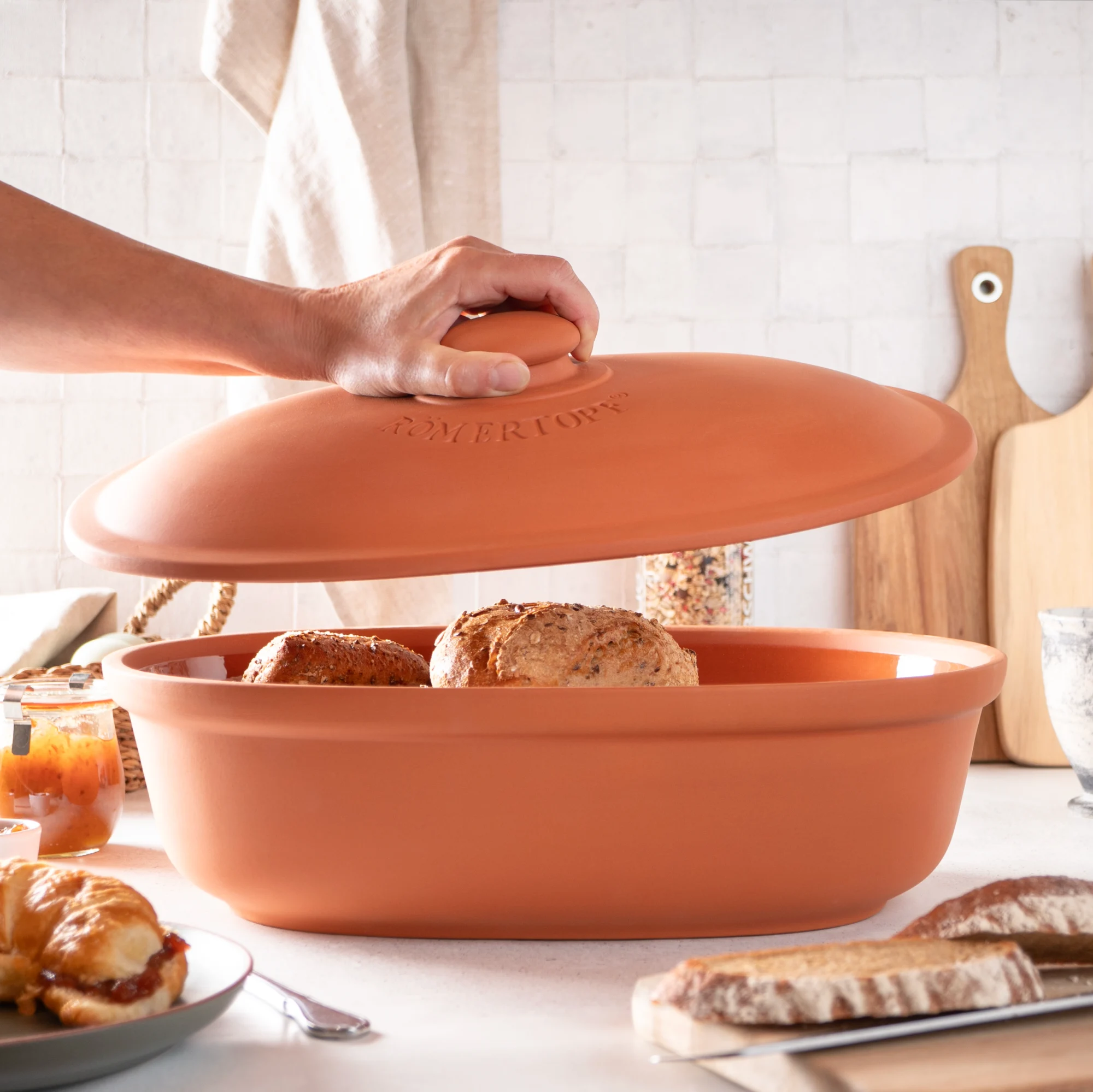 Römertopf Brottopf Maxi aus Terracotta – Frischetopf zur Aufbewahrung von Brot und Brötchen Römertopf Brottopf Maxi aus Terrakotta mit passendem Deckel, oval geformt, naturbelassene Oberfläche, auf hellem Untergrund stehend.