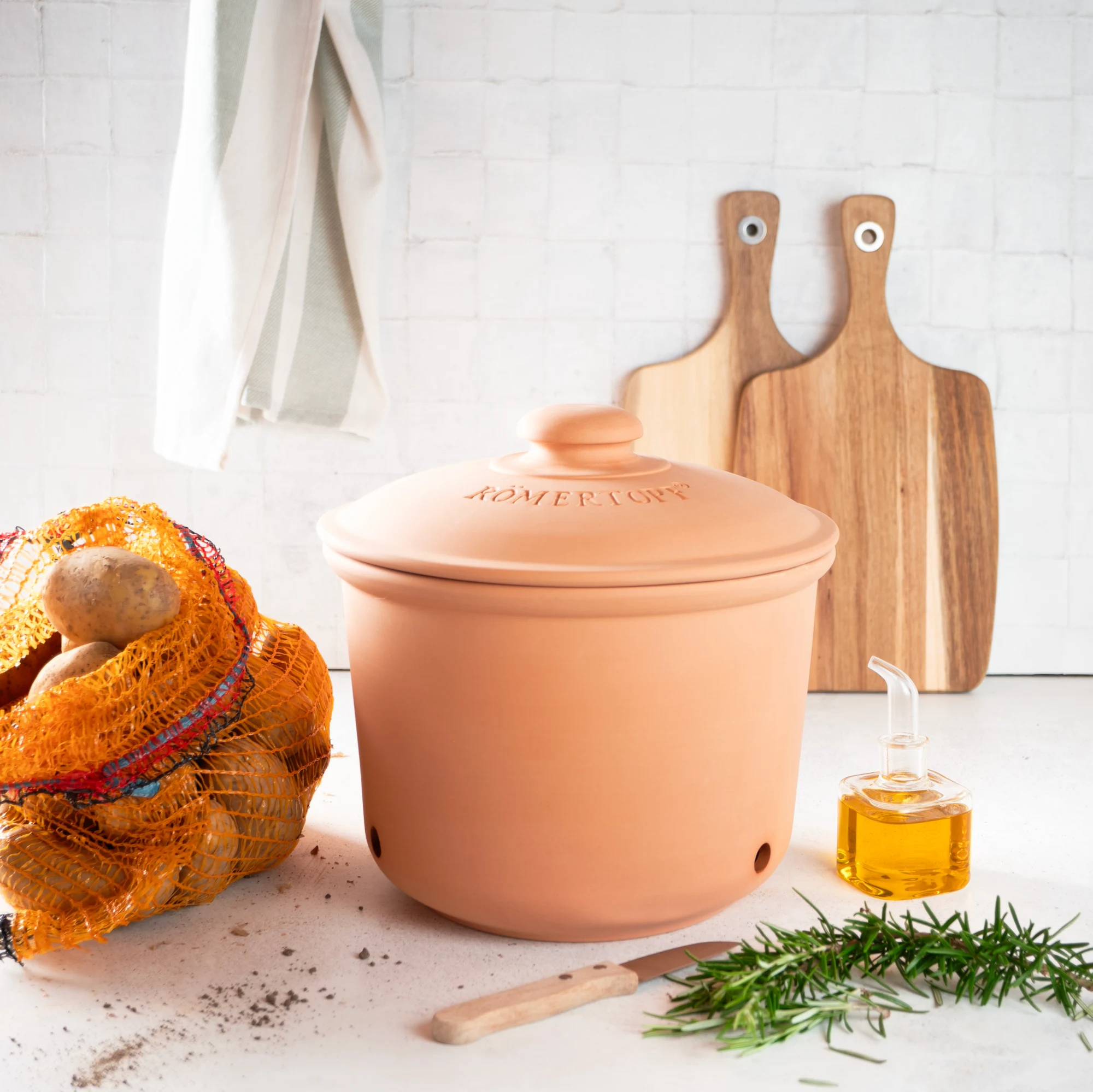 Römertopf Kartoffeltopf Maxi Plus aus Terracotta – atmungsaktiver Topf zur Lagerung von Kartoffeln Großer Römertopf Kartoffeltopf aus naturbelassener Terrakotta mit Deckel, seitlichen Griffen und eingeprägtem „RÖMERTOPF“-Schriftzug, stehend auf weißem Hintergrund.