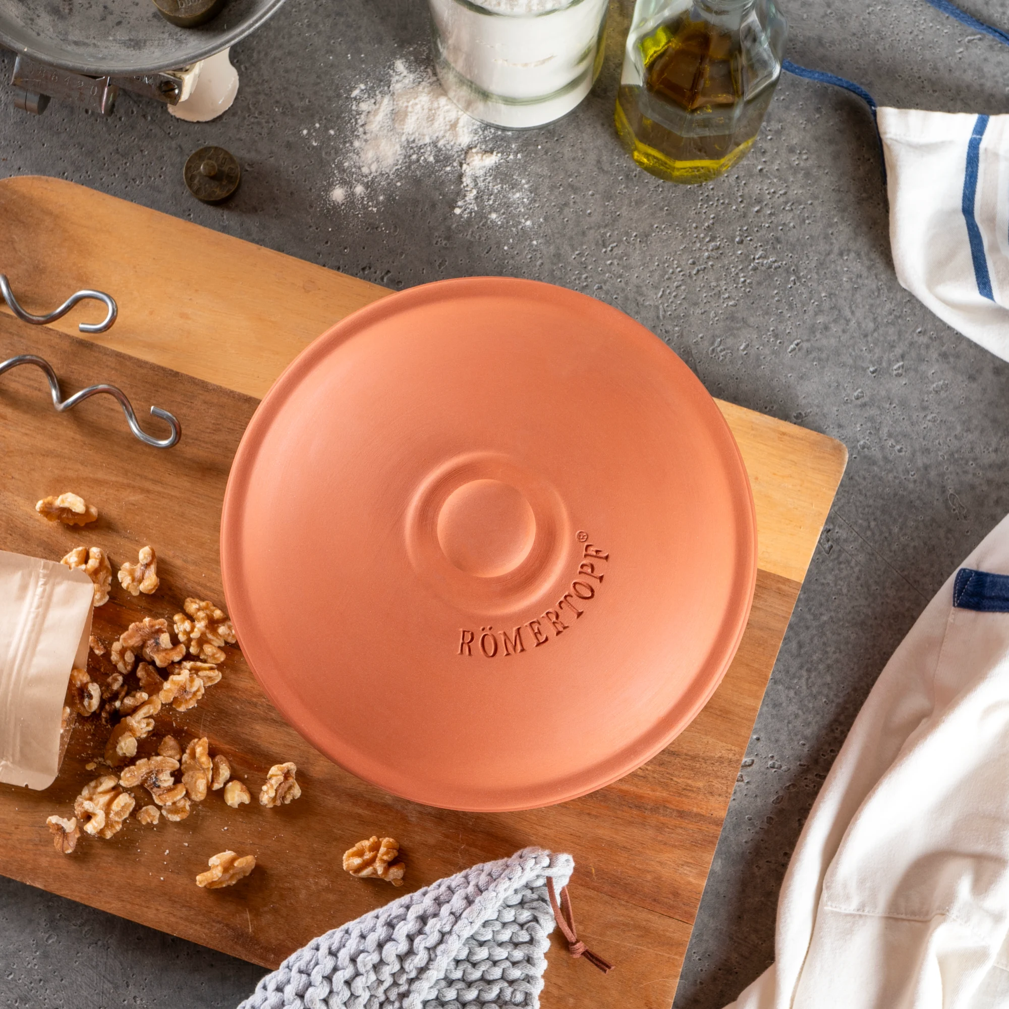Römertopf Brotbacktopf aus Terrakotta – Perfekt für knuspriges Brot – Nachhaltig und natürlich backen Runde, terrakottafarbene Brotbackform aus Ton mit passendem Deckel und zwei seitlichen Griffen, beides unglasiert im klassischen Römertopf-Design, auf neutralem Hintergrund.