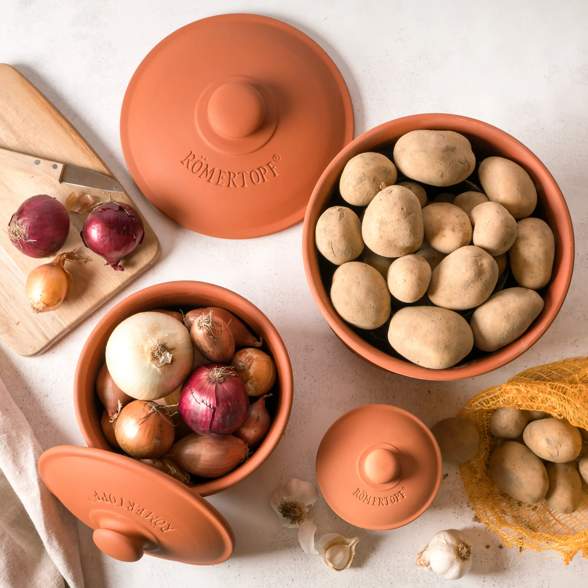 Römertopf Vorratstopf Set aus Terrakotta – 3-teilige Aufbewahrung in natürlicher Tonoptik Zweiteiliges Vorratstopf-Set aus naturfarbener Terrakotta mit Deckeln, gestaltet für die Aufbewahrung von Lebensmitteln; beide Töpfe stehen nebeneinander auf heller Fläche.
