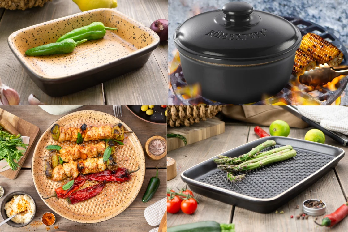 Ein rechteckiger Römertopf aus Naturton steht auf einem Grillrost mit geöffnetem Deckel; darin sind goldbraune Hähnchenschenkel, Rosmarinzweige und Gemüse wie Paprika und Zucchini zu sehen. Im Hintergrund unscharf ein Garten mit Grünpflanzen.