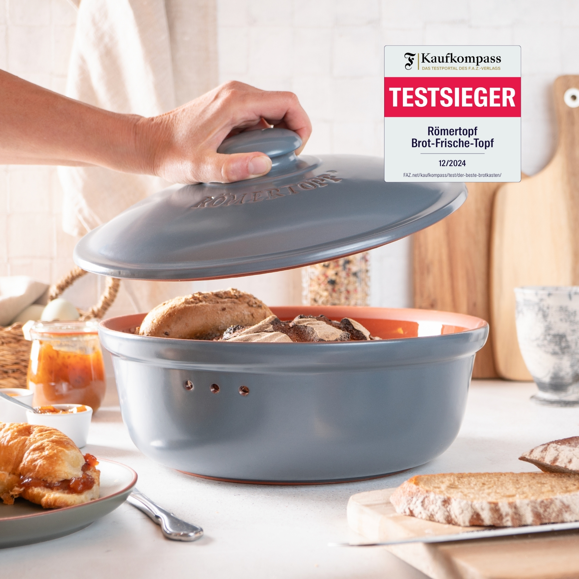 Römertopf Brottopf rund in Blaugrau – Testsieger zur Brotaufbewahrung für langanhaltende Frische Frischhaltedose aus Keramik in Blauton von Römertopf mit Deckel, auf weißem Untergrund platziert; als Testsieger ausgezeichnet.