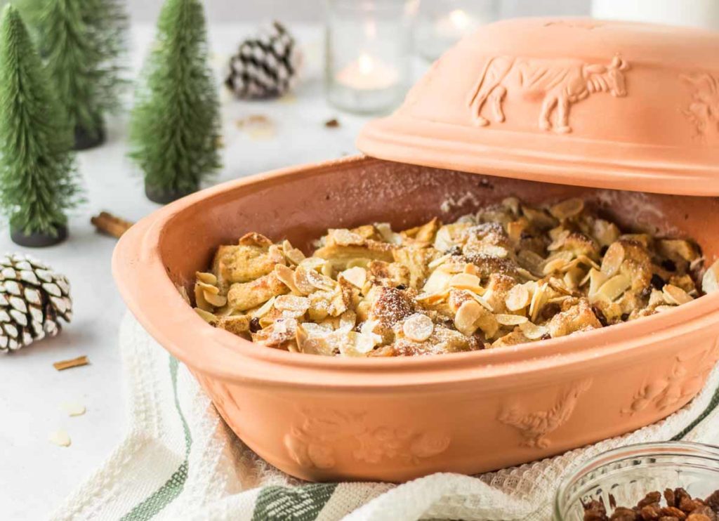 Keramikbräter mit Mandelauflauf, im Hintergrund kleine Tannenbäume und Tannenzapfen als Dekoration.