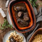 Rinderrouladen in Bratensauce, serviert mit Spätzle auf einem rustikalen Holztisch, gewürzt mit frischen Kräutern.