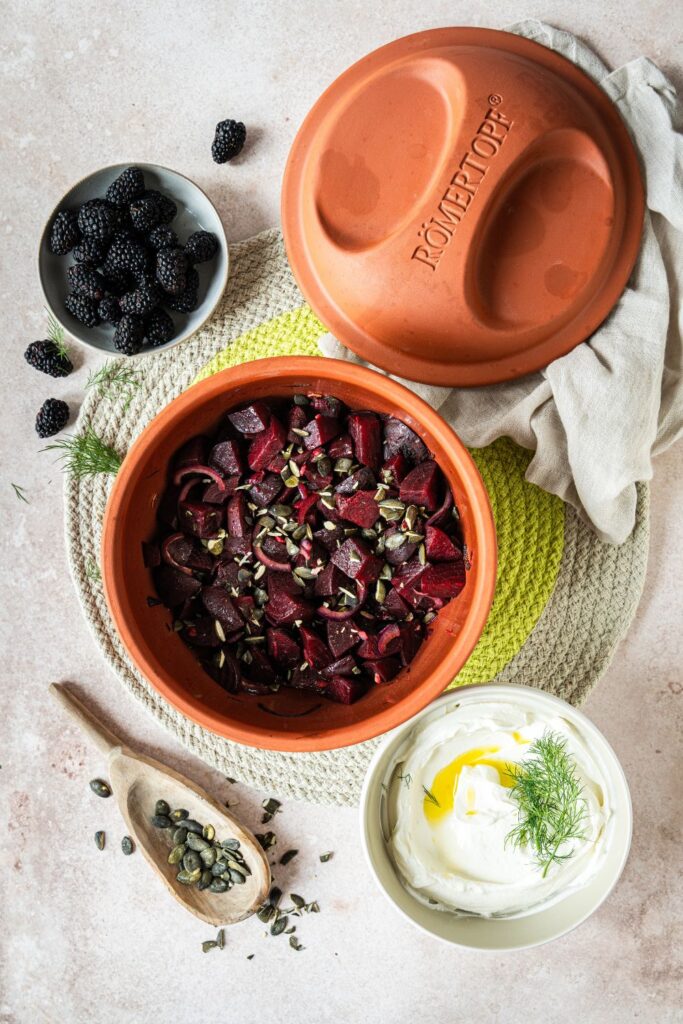 Gebackene Rote Bete mit Kürbiskernen im Römertopf Multi-Bräter, daneben cremiger Labneh mit Dill und frische Brombeeren