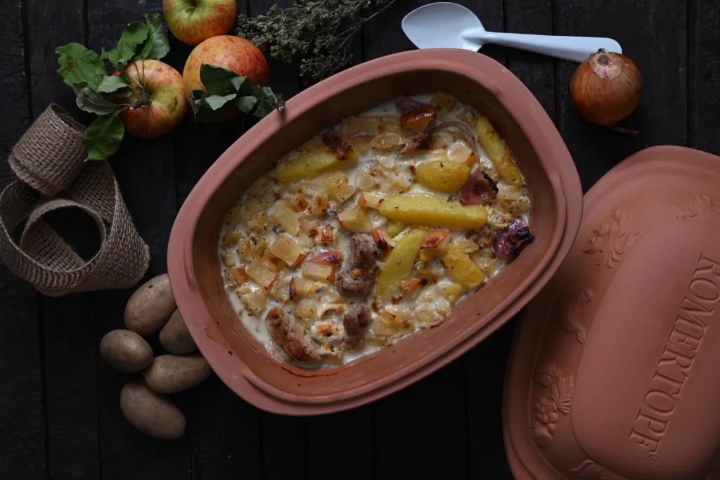 Herbstlicher Auflauf mit Kartoffeln, Äpfeln und Bratwurst im Römertopf